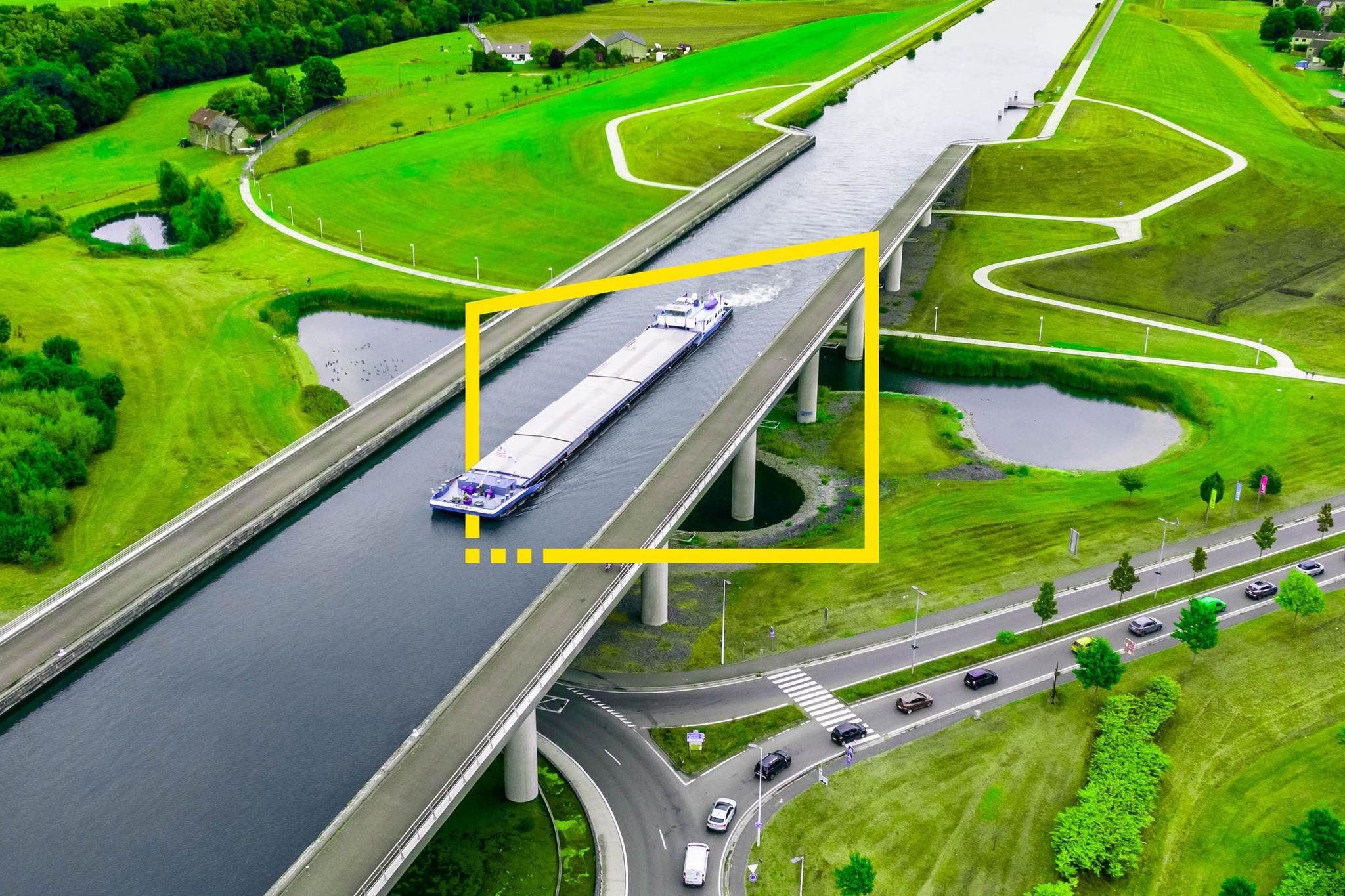 Aerial view of the sart canal bridge crossing road in the green landscape of belgium
