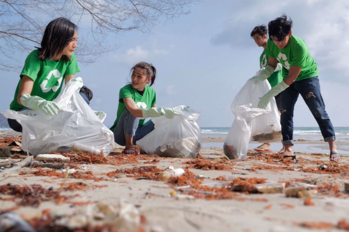 A photograph of a group of volunteers cleaning a beach