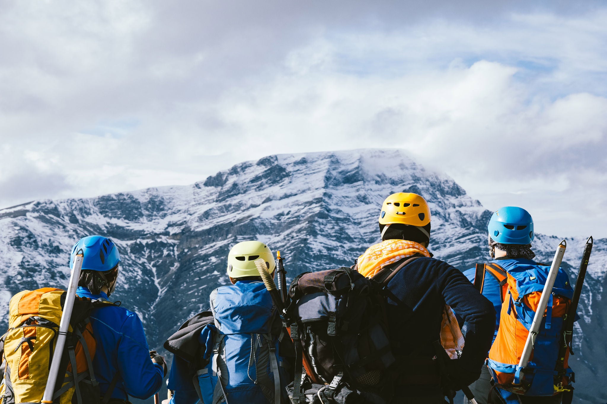 Group of alpine climbers watching the beautiful landscape  in the peak of mountain in winter