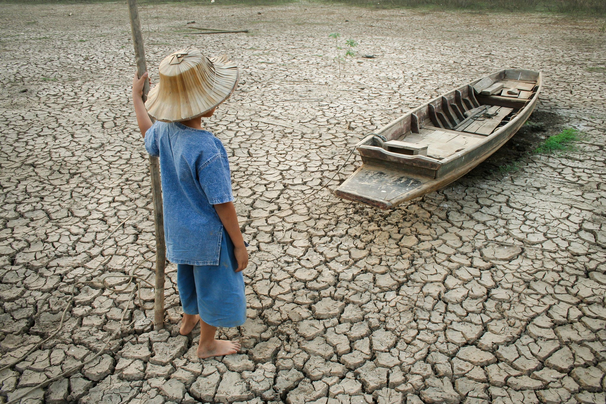 Enfant regardant une barque sans eau