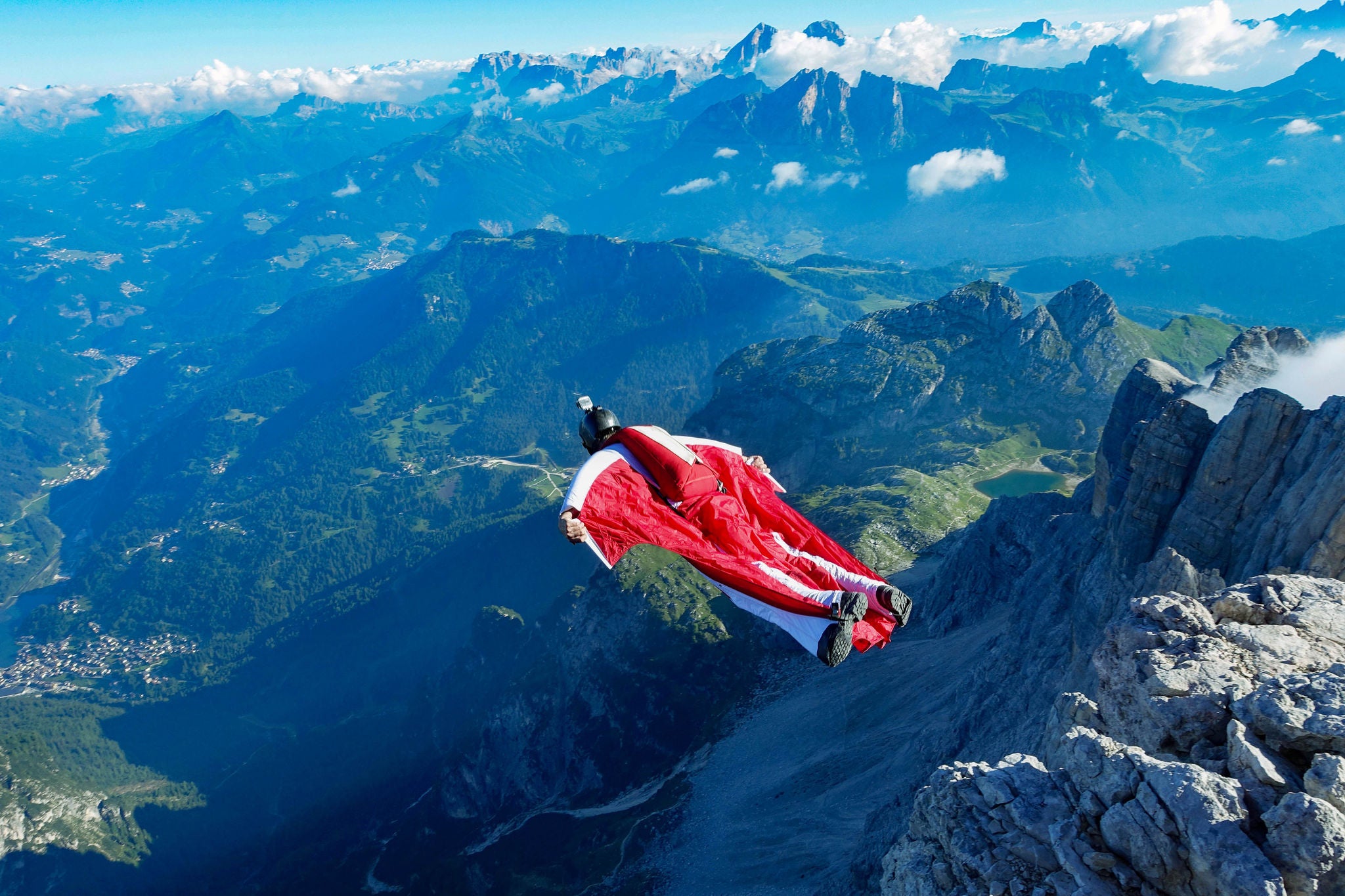 Männlicher Wingsuit-BASE-Springer beim Absprung vom Klippenrand