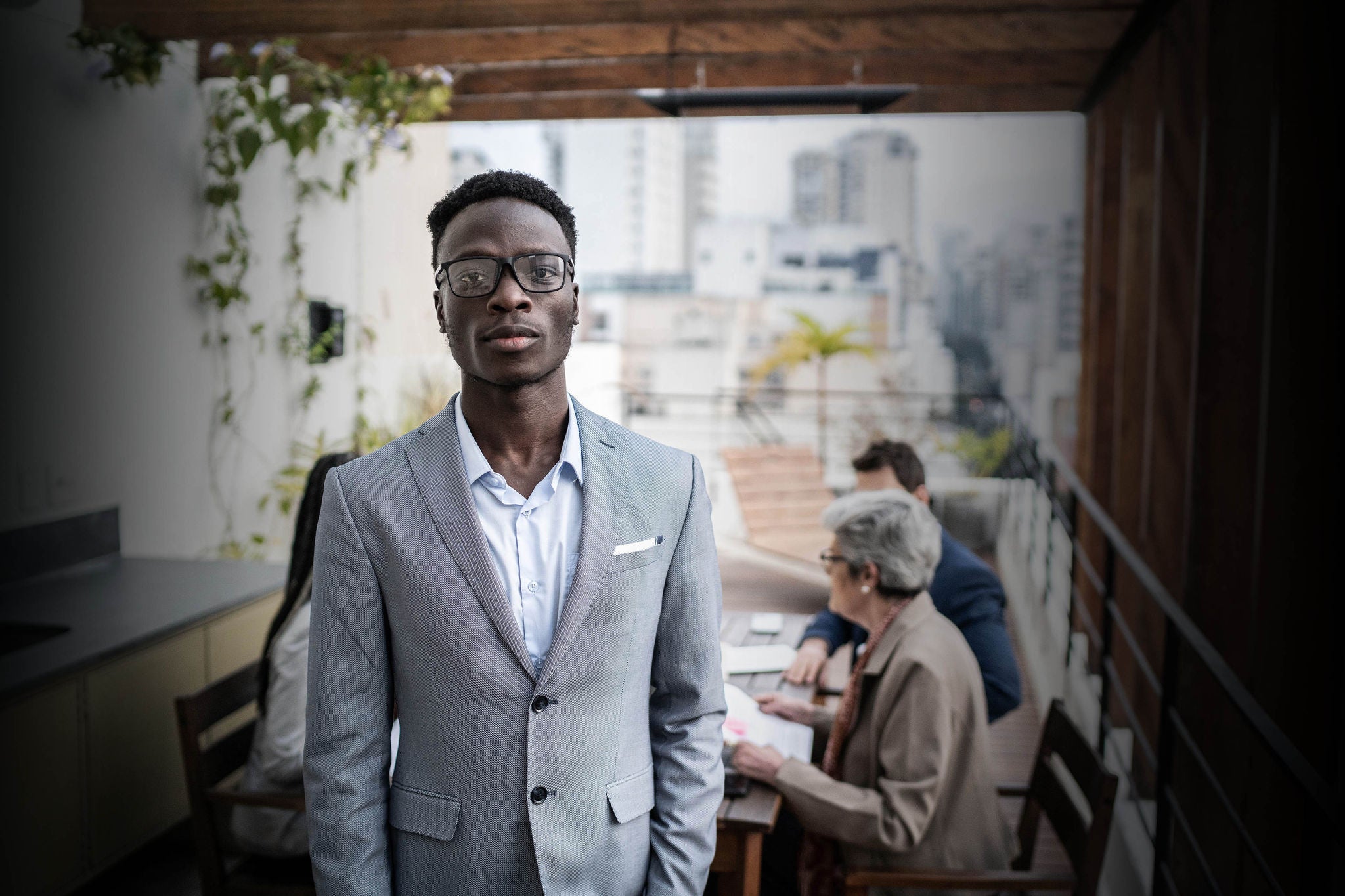 Portrait of a serious businessman outdoors - team meeting on the background