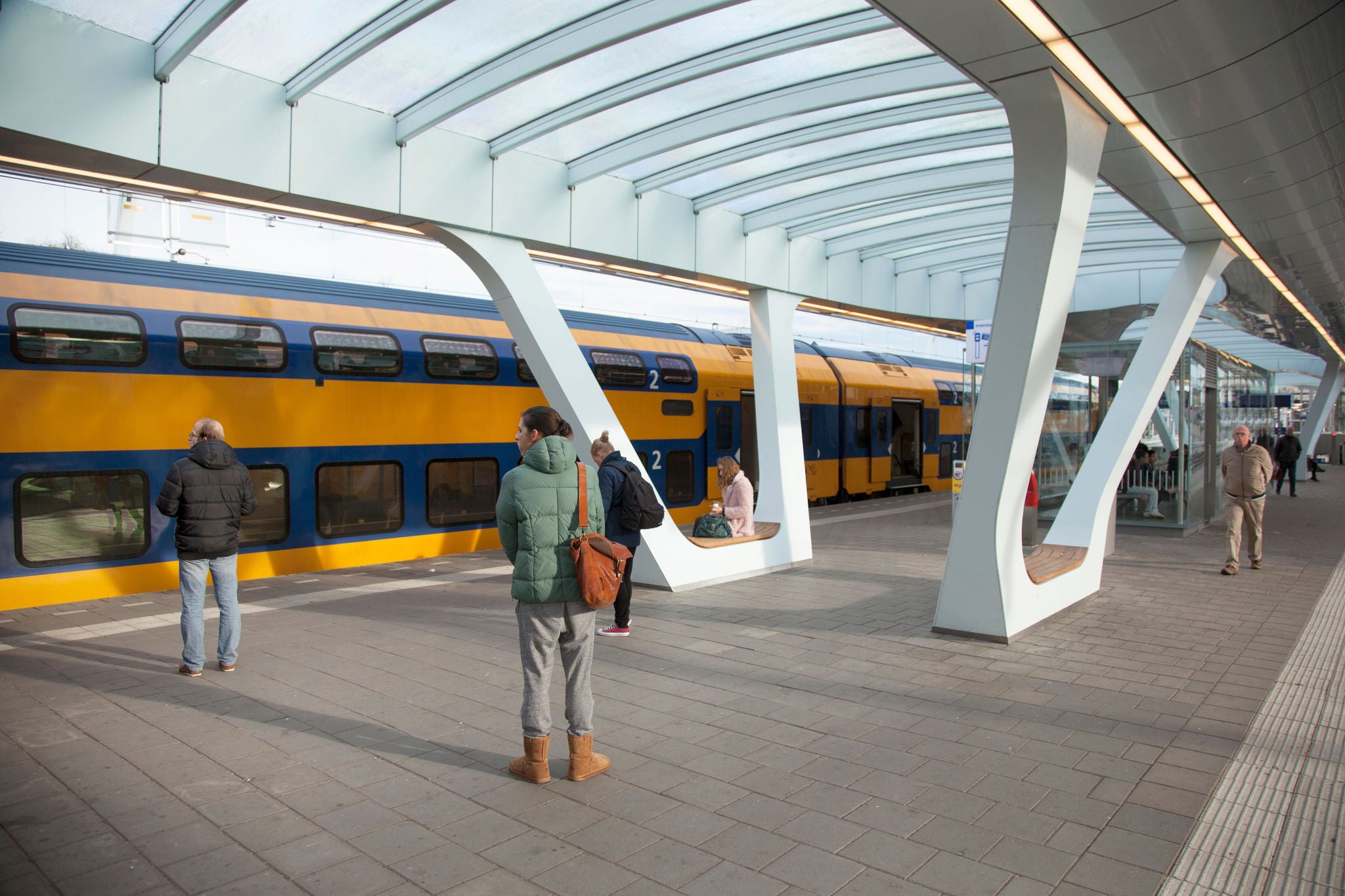 People are standing on the platform waiting for the train.