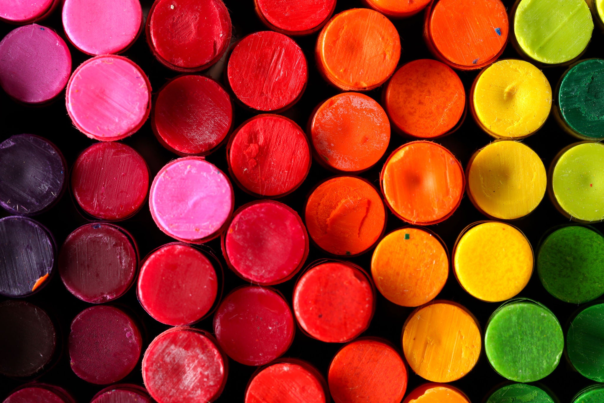 Box of crayons in a rainbow of colors background