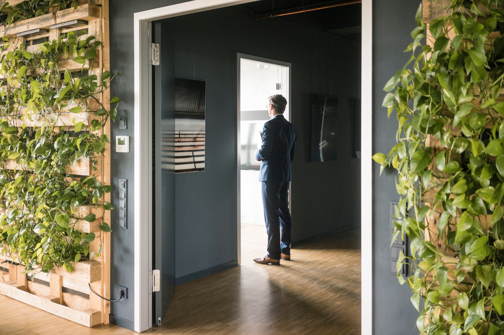 Mature businessman standing at a door in green office