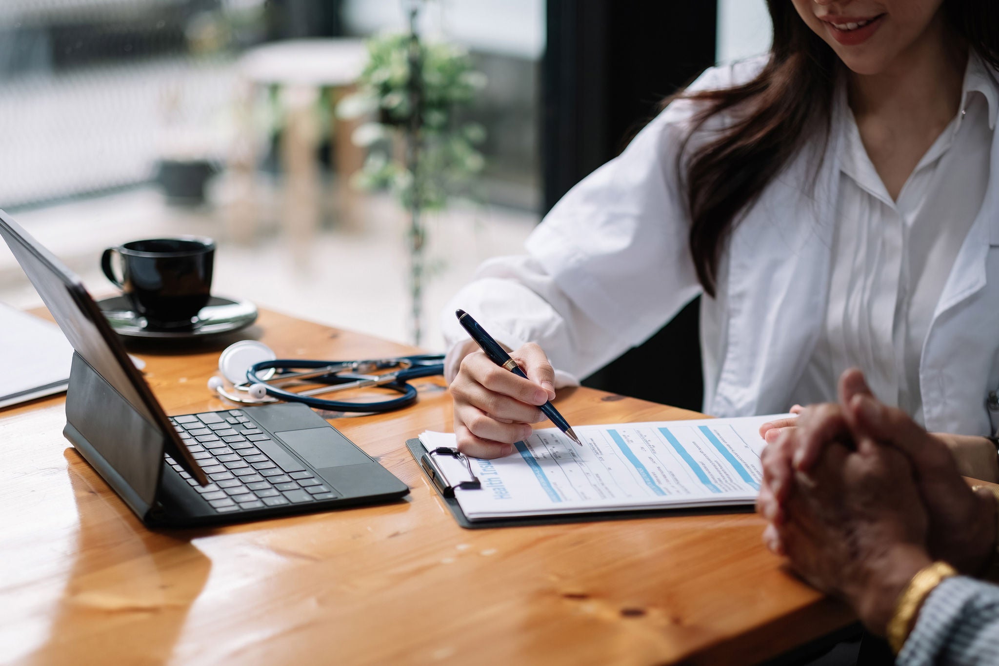 Female health insurance broker presenting his insurance benefits to businessman fill out insurance policy. 