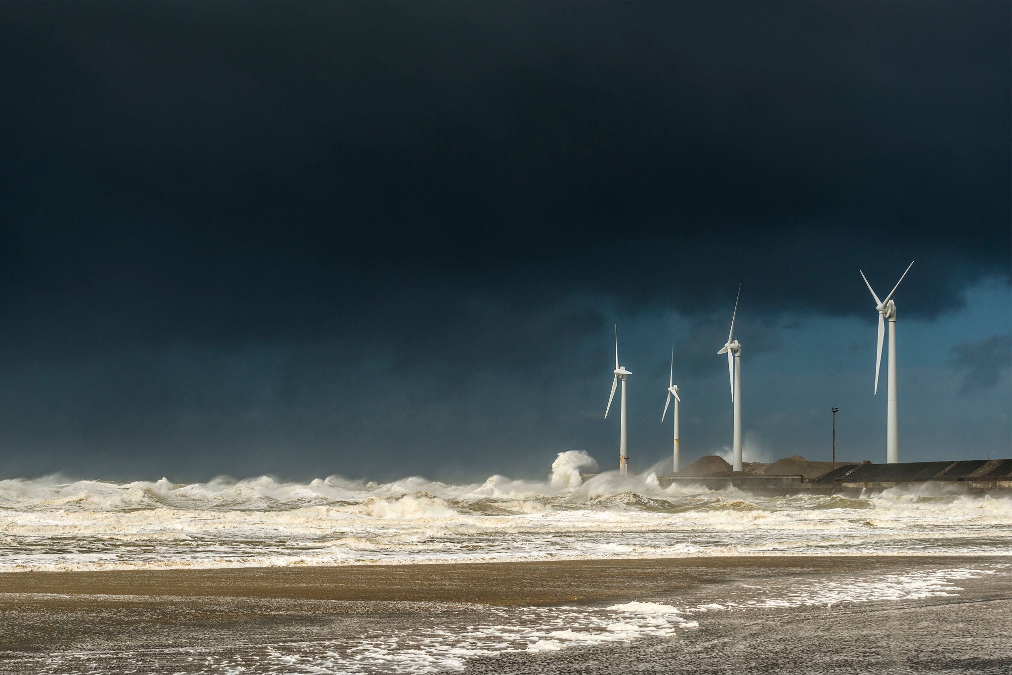 Four wind turbines amidst fierce storm waves and clouds at coast, Boulogne-sur-Mer, Nord-pas-de-Calais, France