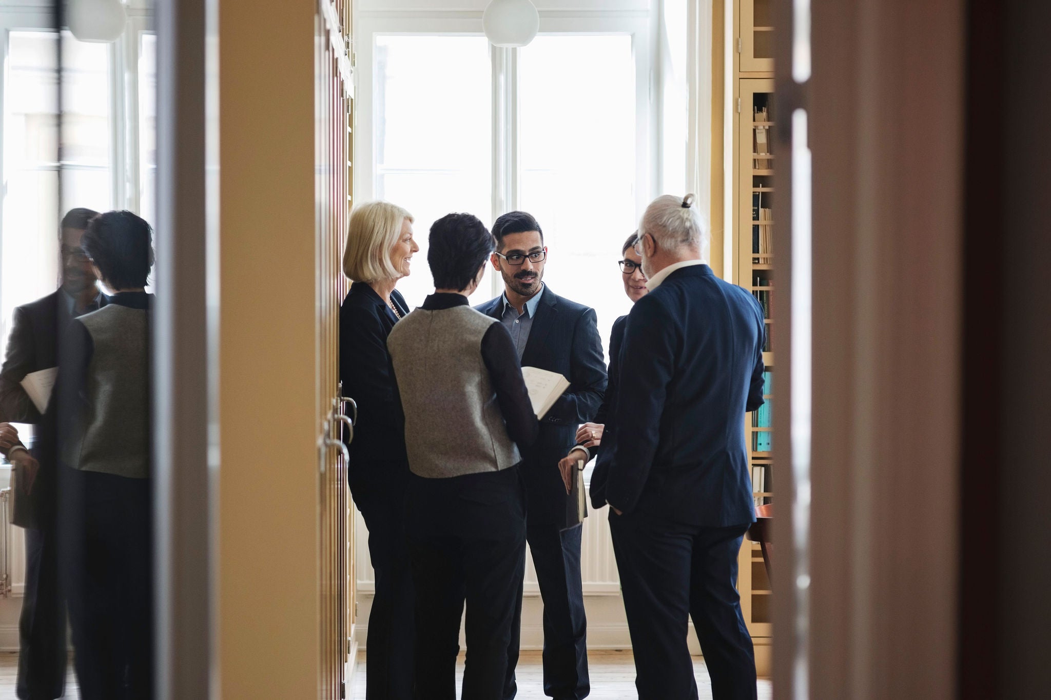 Lawyers discussing while standing in library