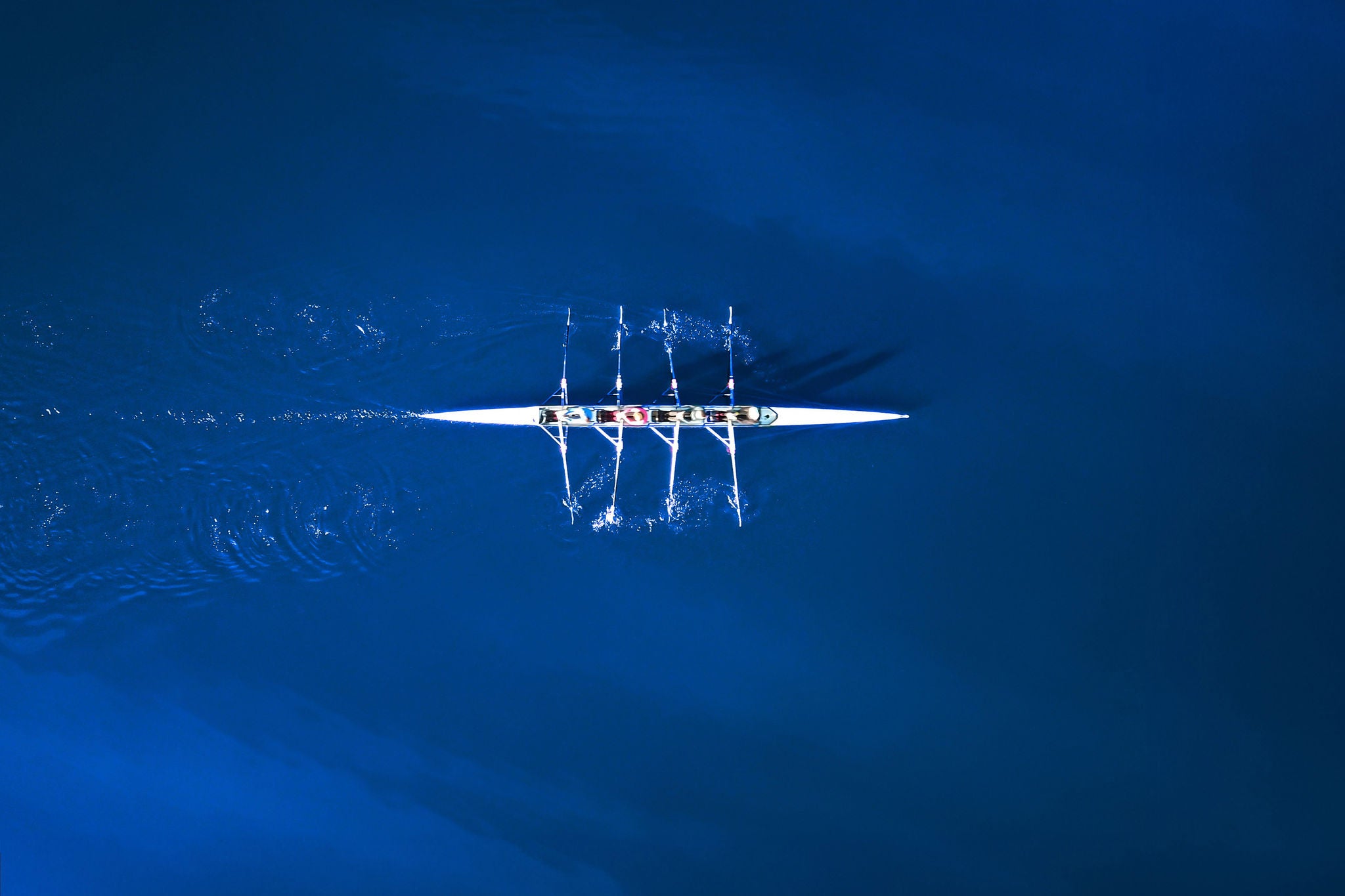 Aerial view of a rowing boat surrounded by blue water