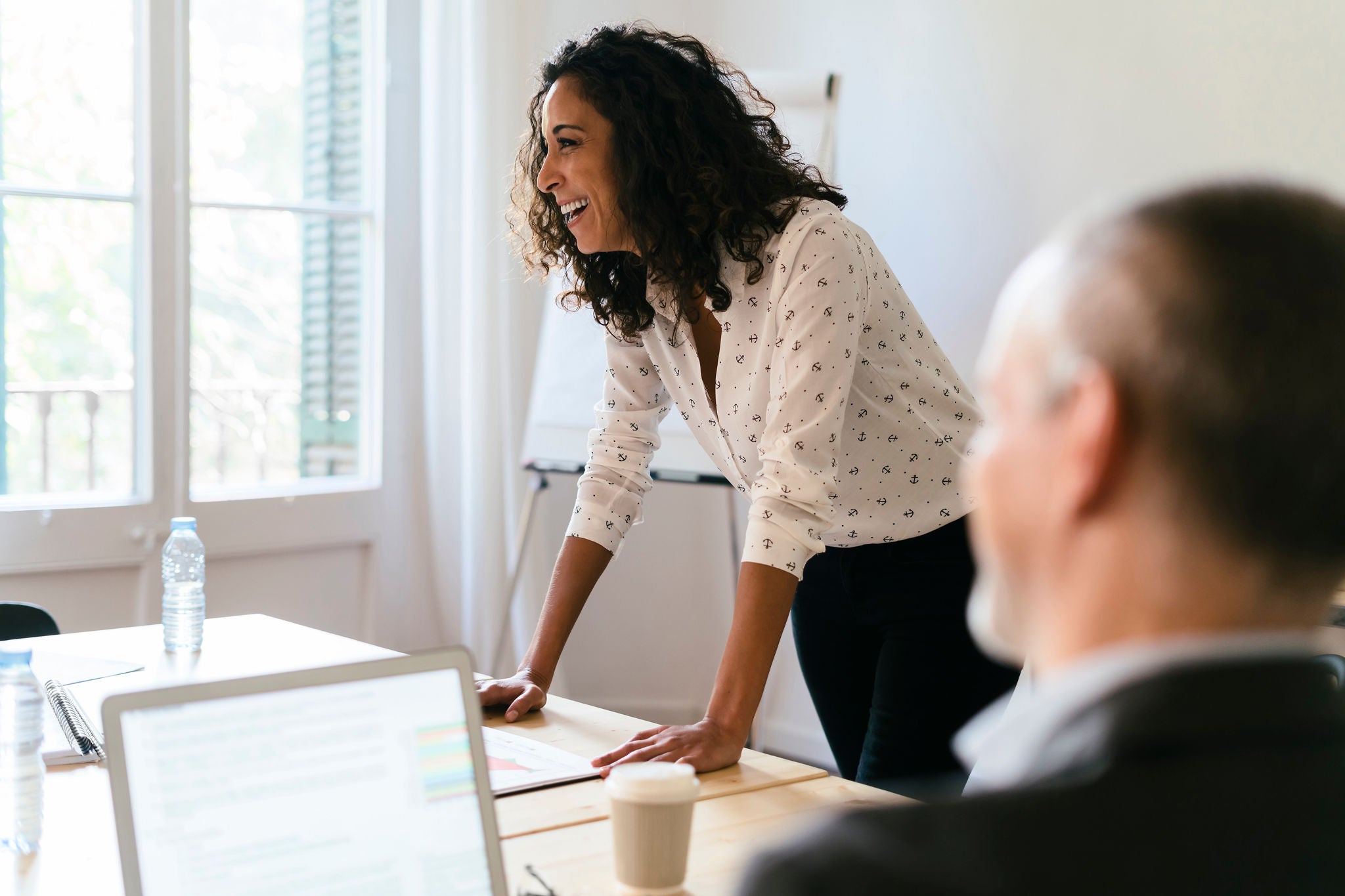 A businesswoman giving a presentation to a group of people in a conference room.