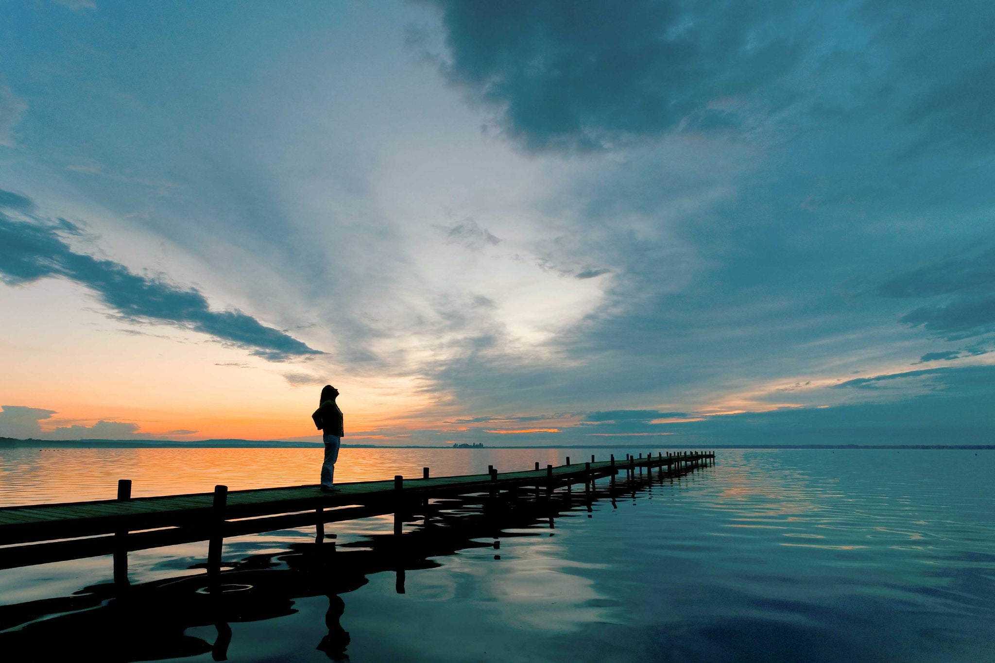 Mujer mirando el oceano en el amanecer