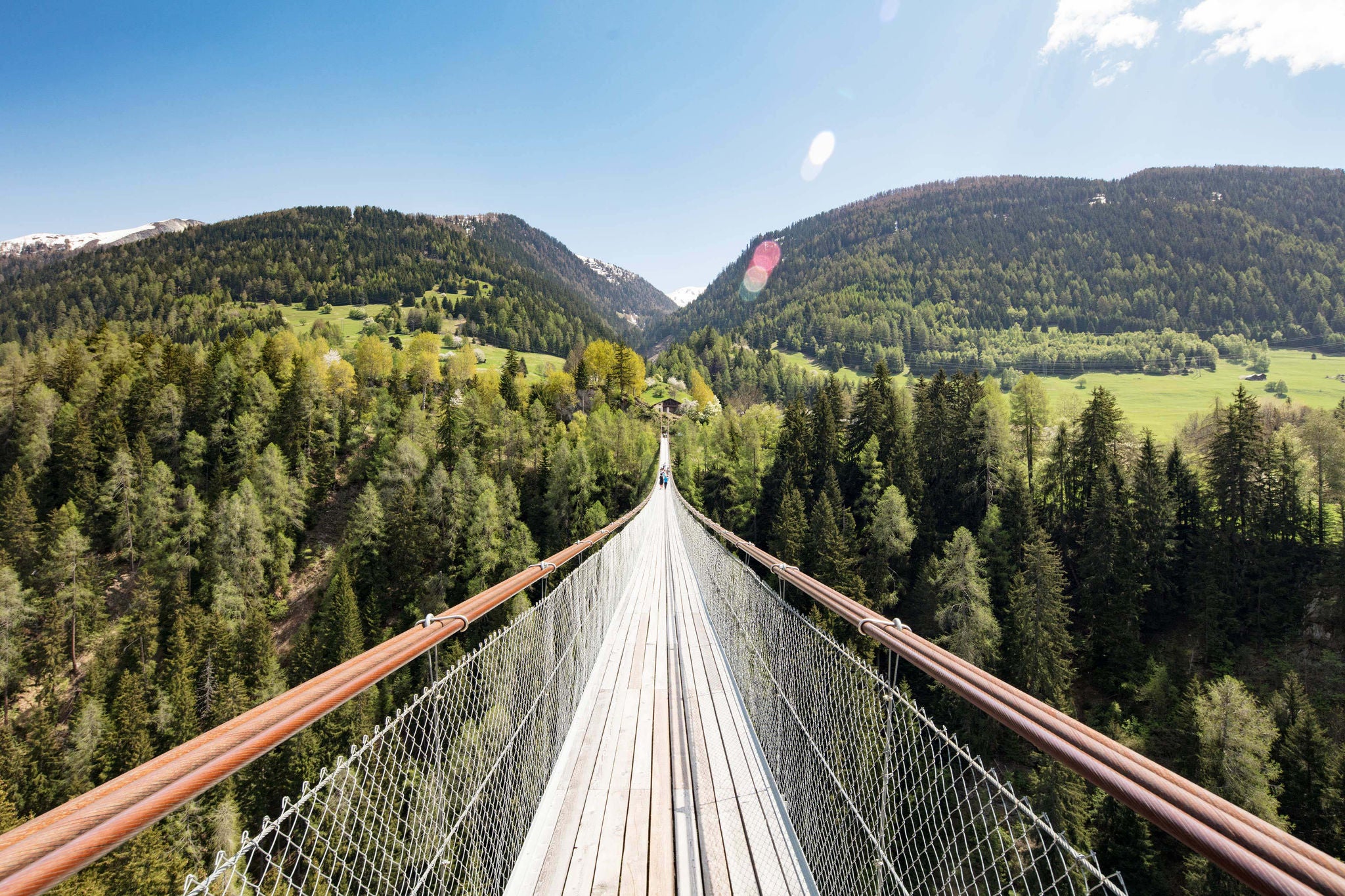 Suspension bridge over young Rhone River near Ernen.