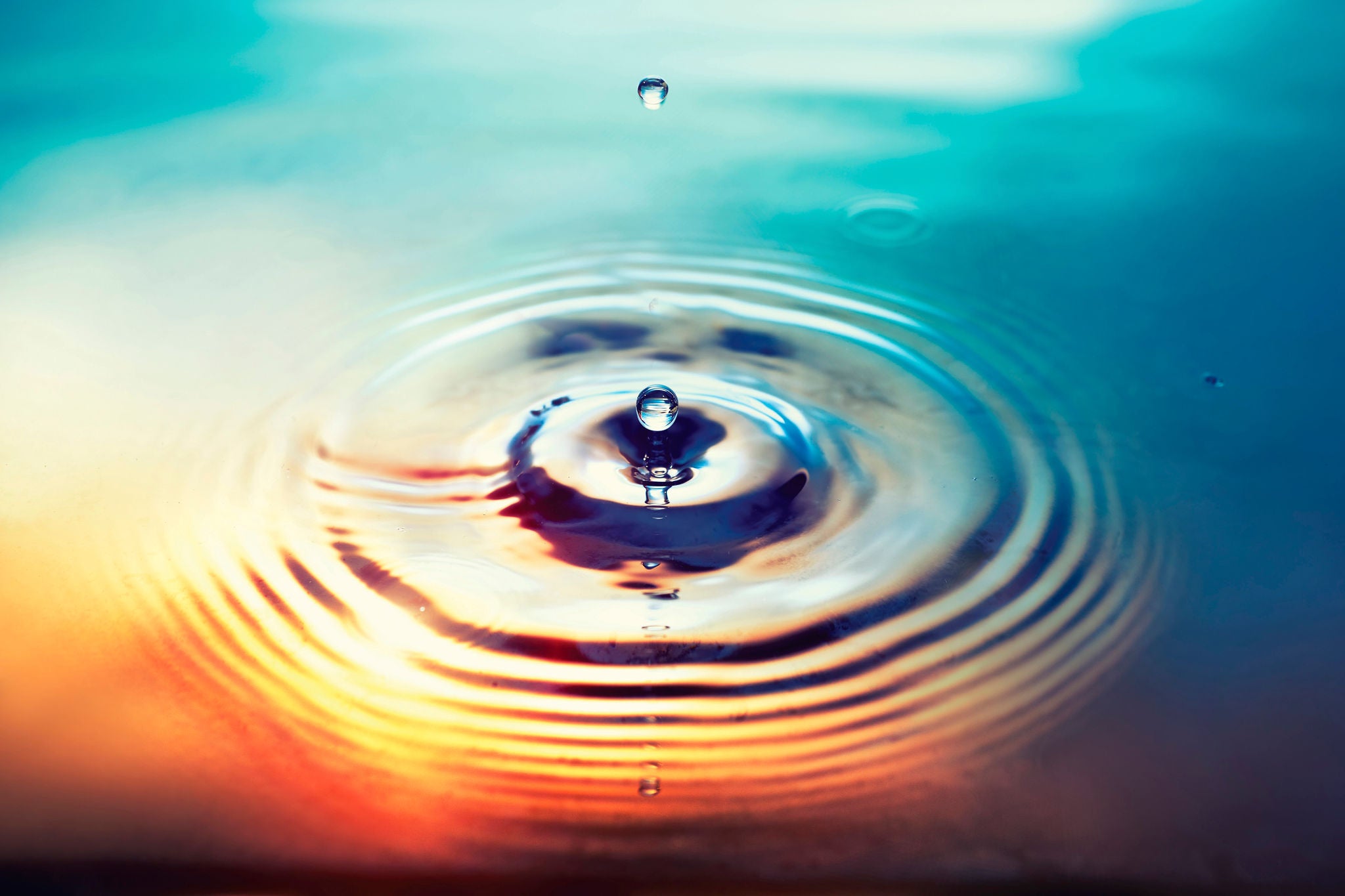 Photo of water droplet falling into a water body