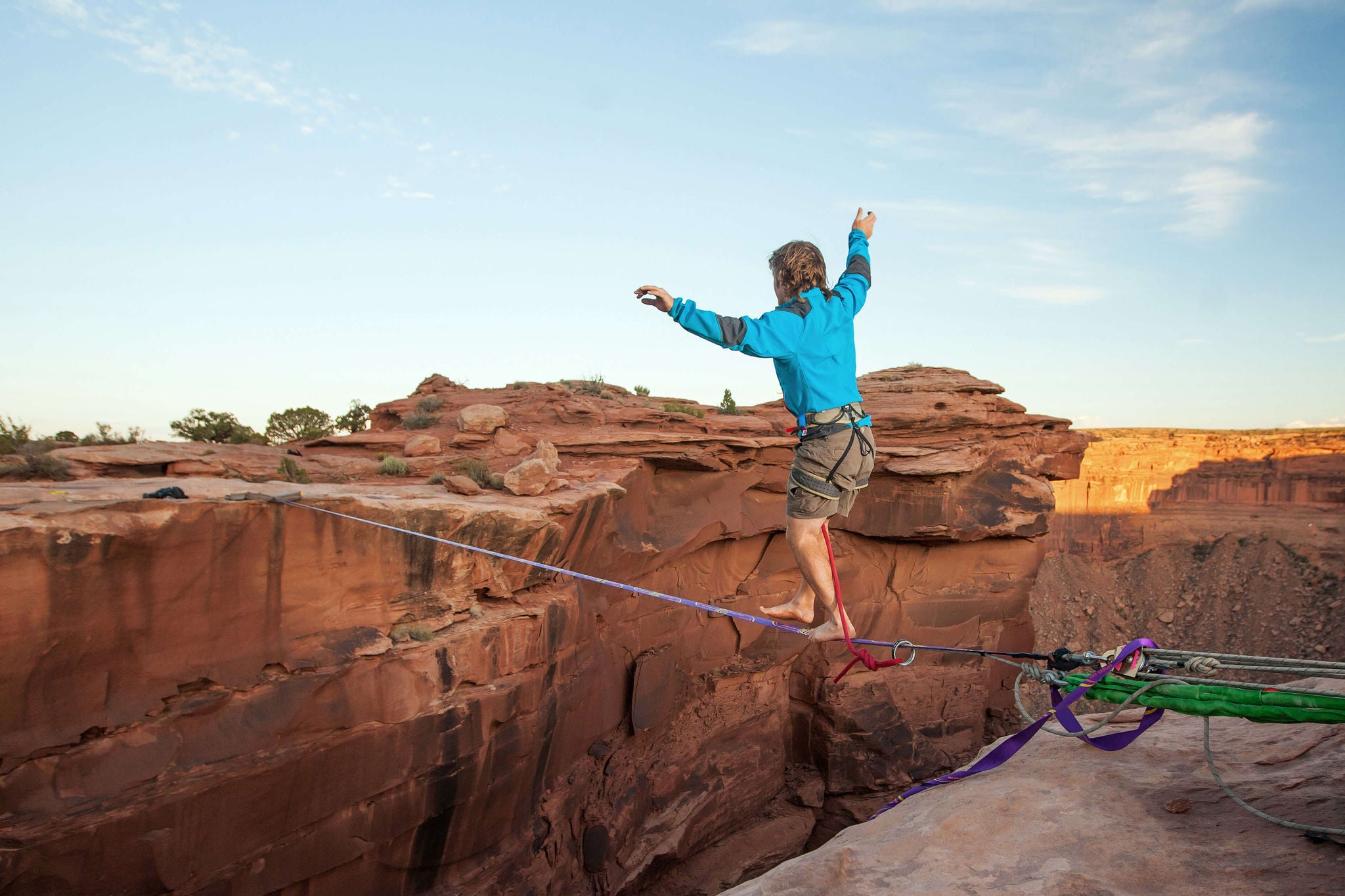  EY - Man walking tightrope over canyon