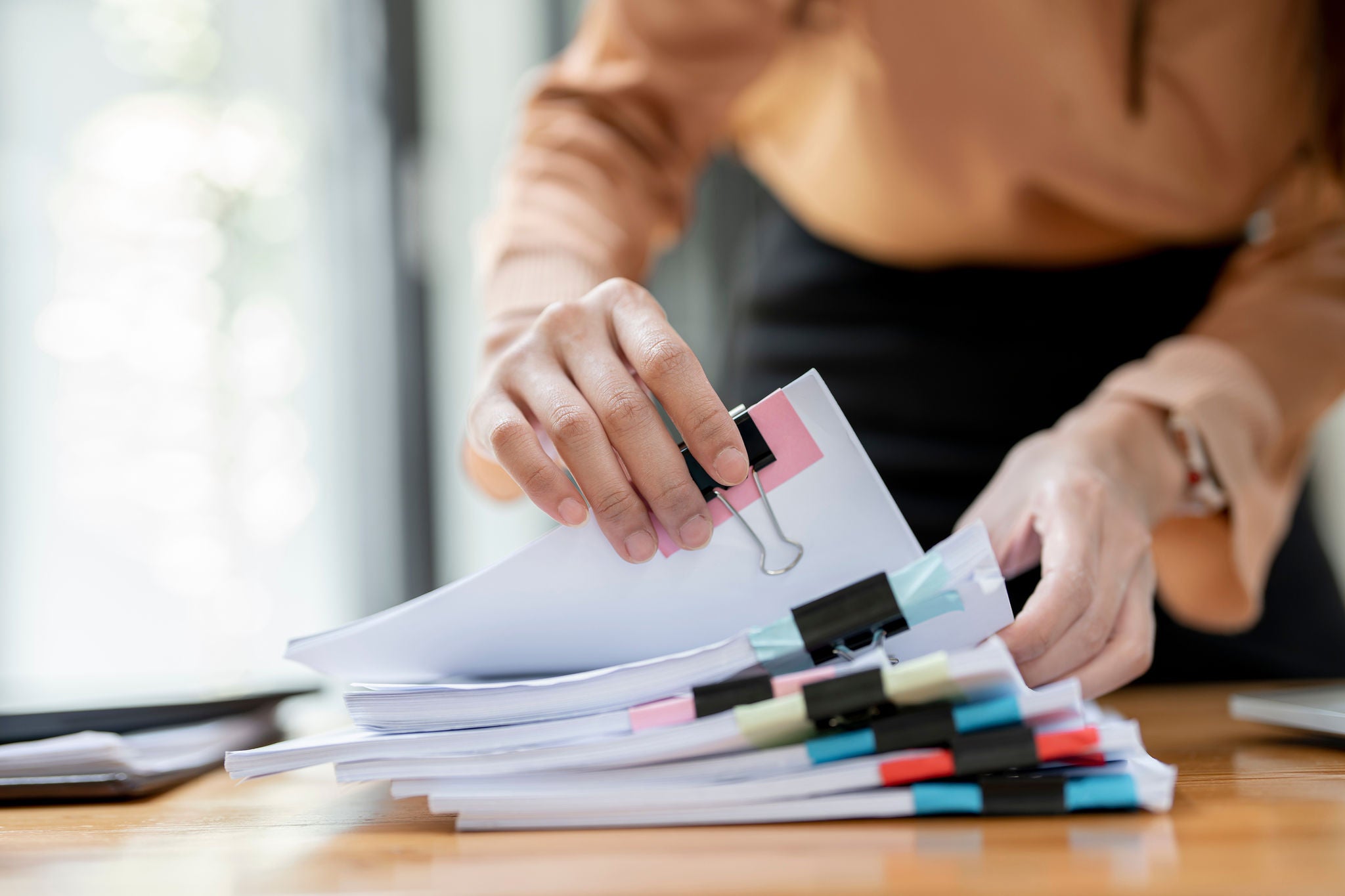 Une personne recherchant un document dans une pile de feuille