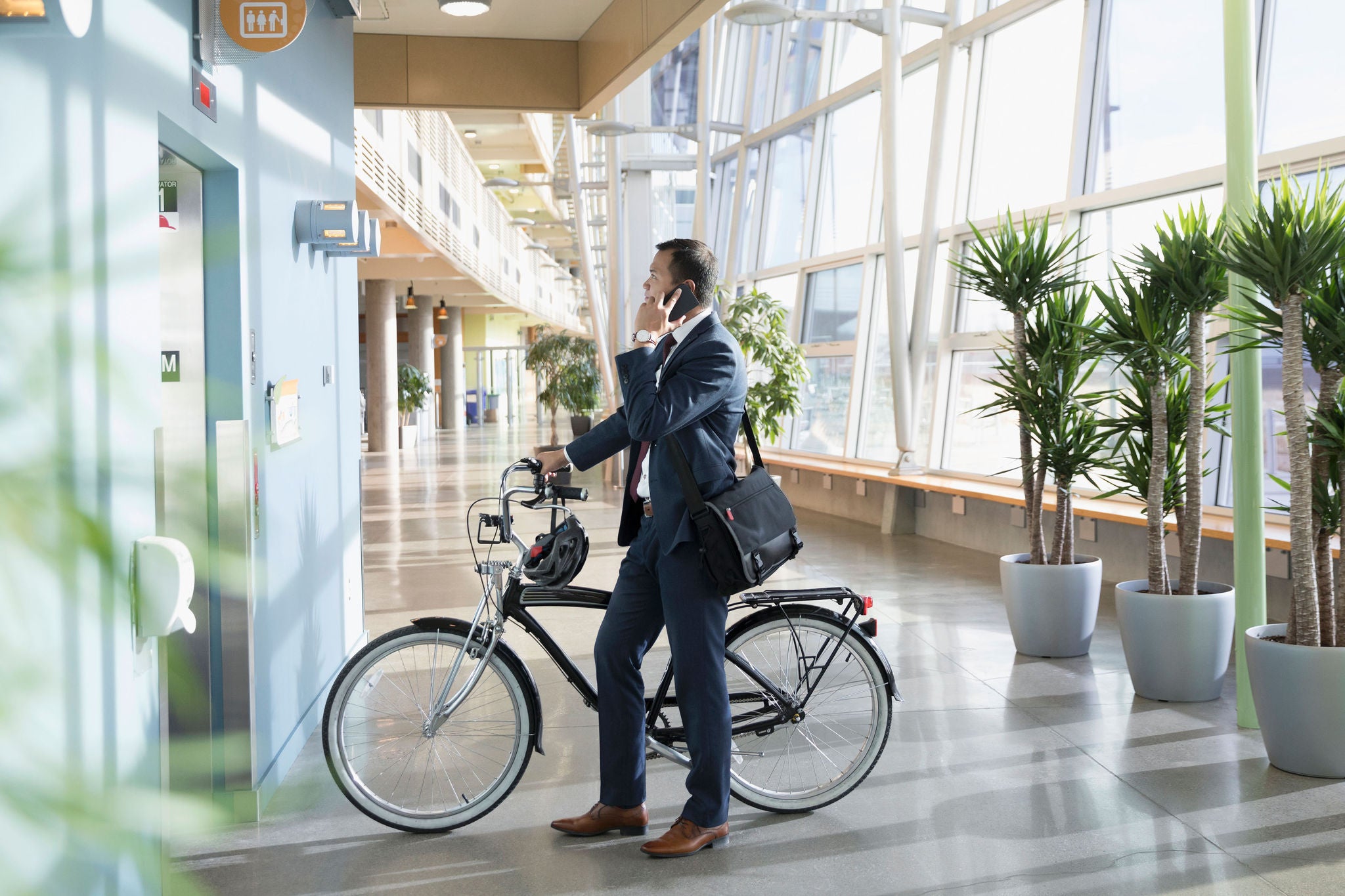 Businessman with bicycle by an elevator