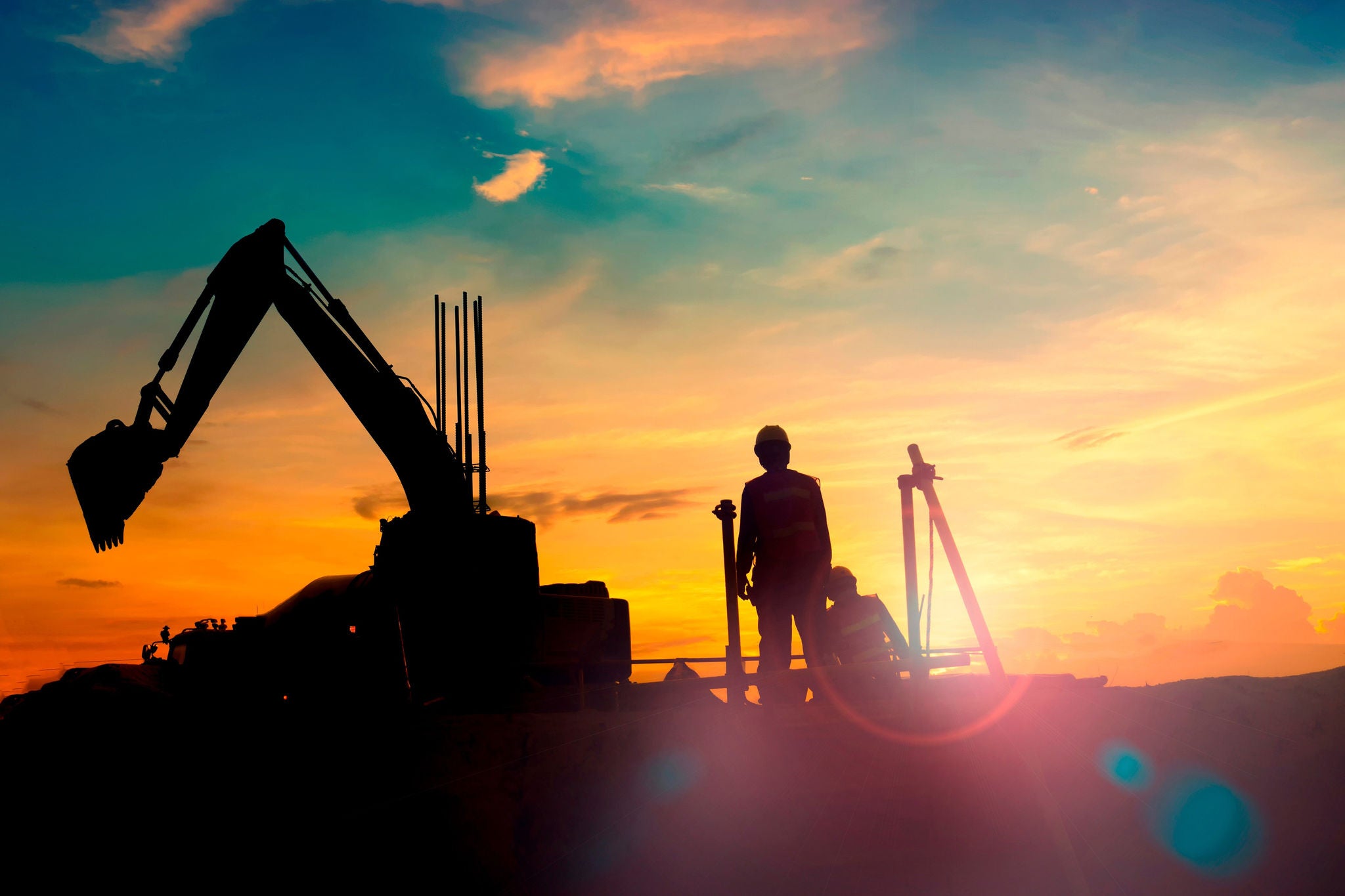 Construction equipments silhouette on sunset