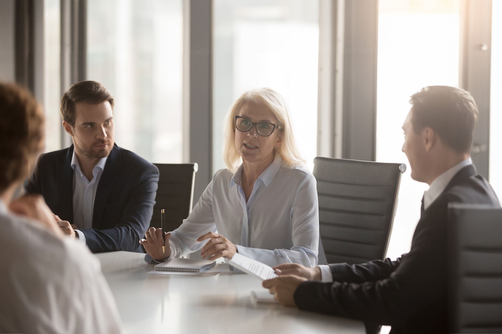 Serious middle aged businesswoman talks at group board executive meeting