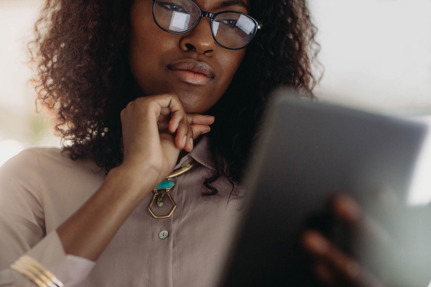 ey woman is thoughtful whilst reading tablet