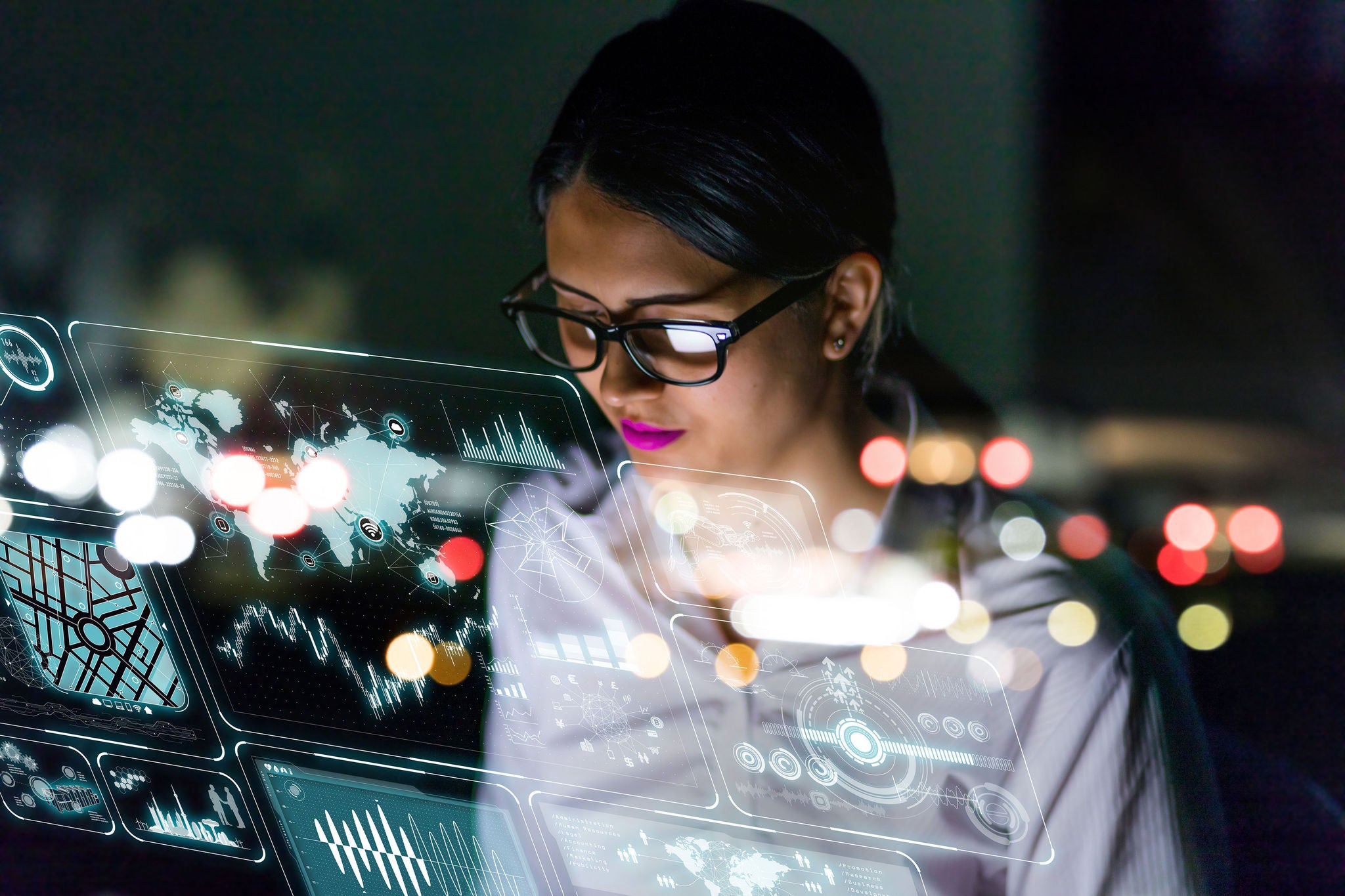 Picture of woman engineer looking at various information in screen of futuristic interface.