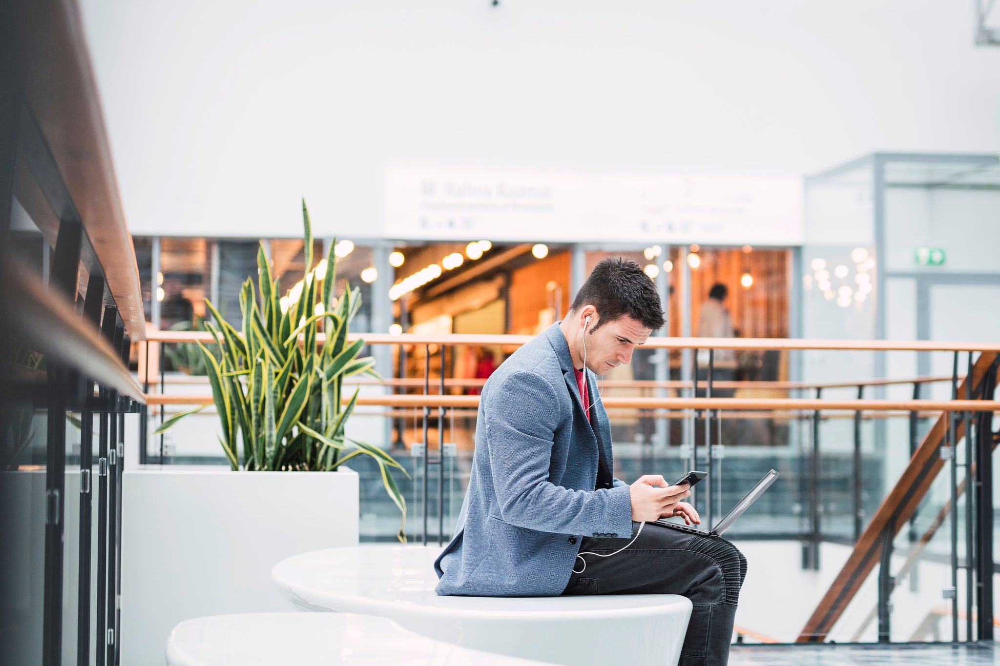 Businessman in lobby of a modern building, using smartphone