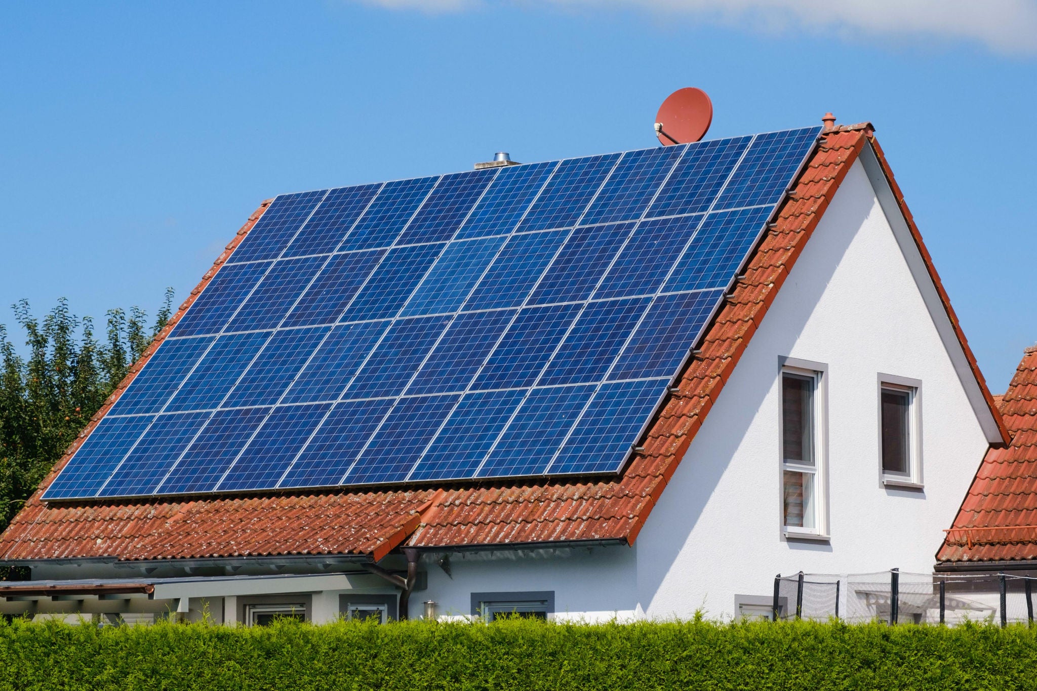 Haus mit Ziegeldach, das mit Solarpanelen bedeckt ist