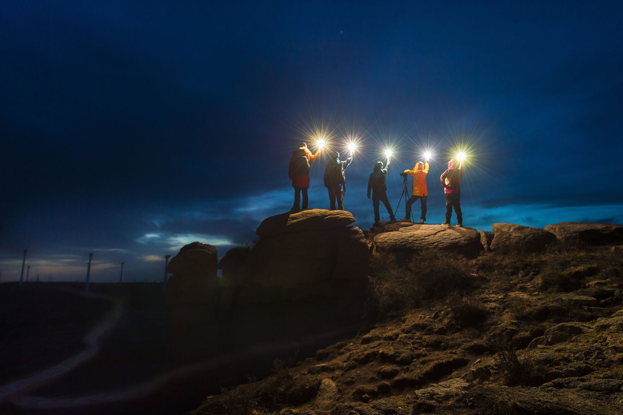 Photograpers standing on a stone with a lamp