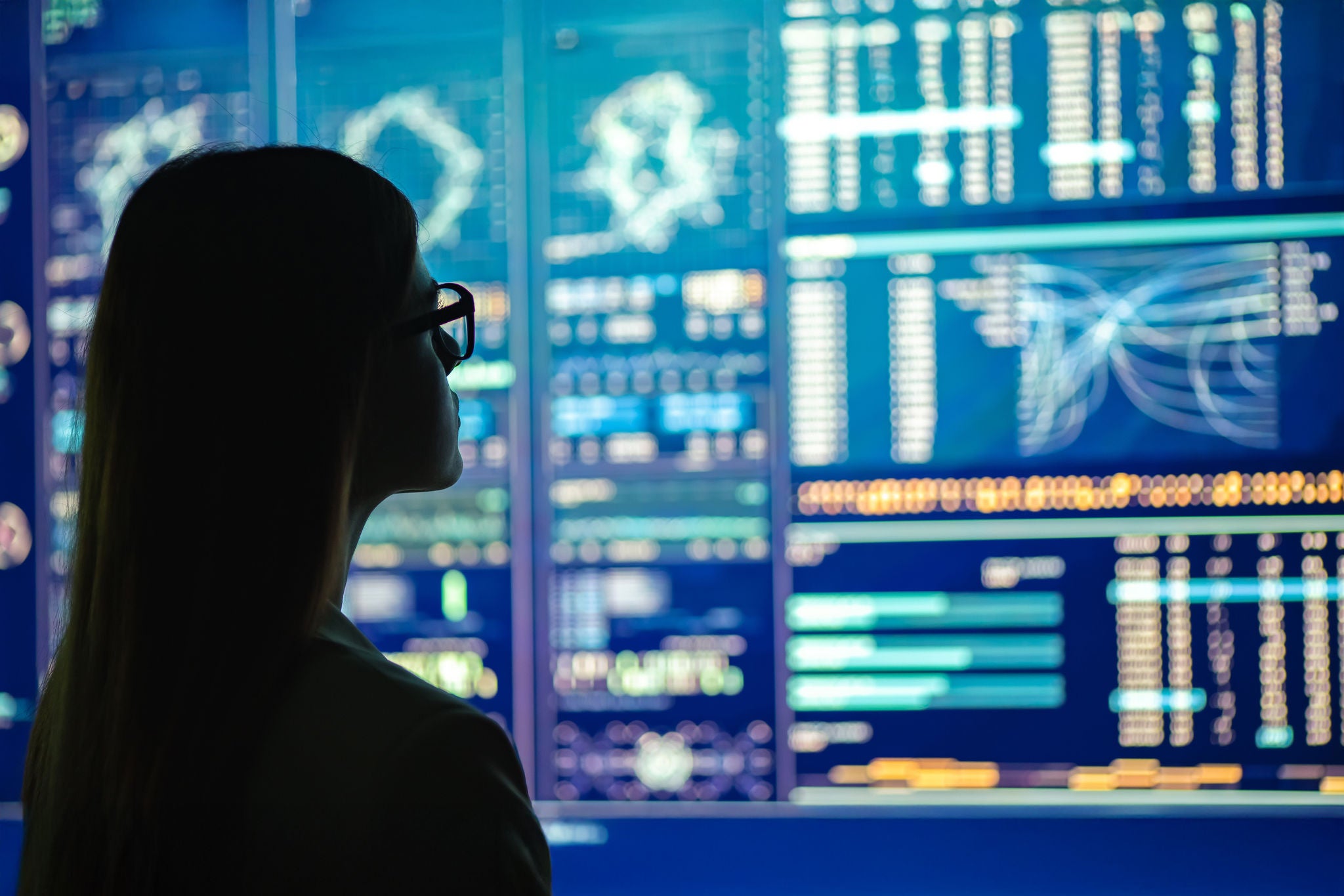 The businesswoman in glasses standing near the display