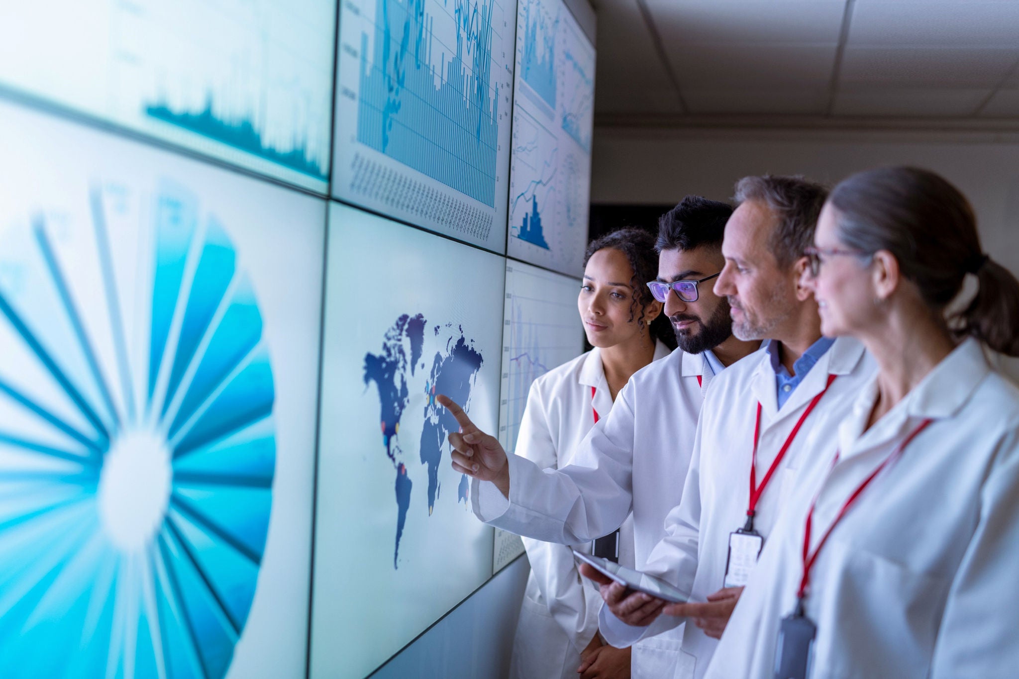 Team of researchers inspecting charts on interactive screens