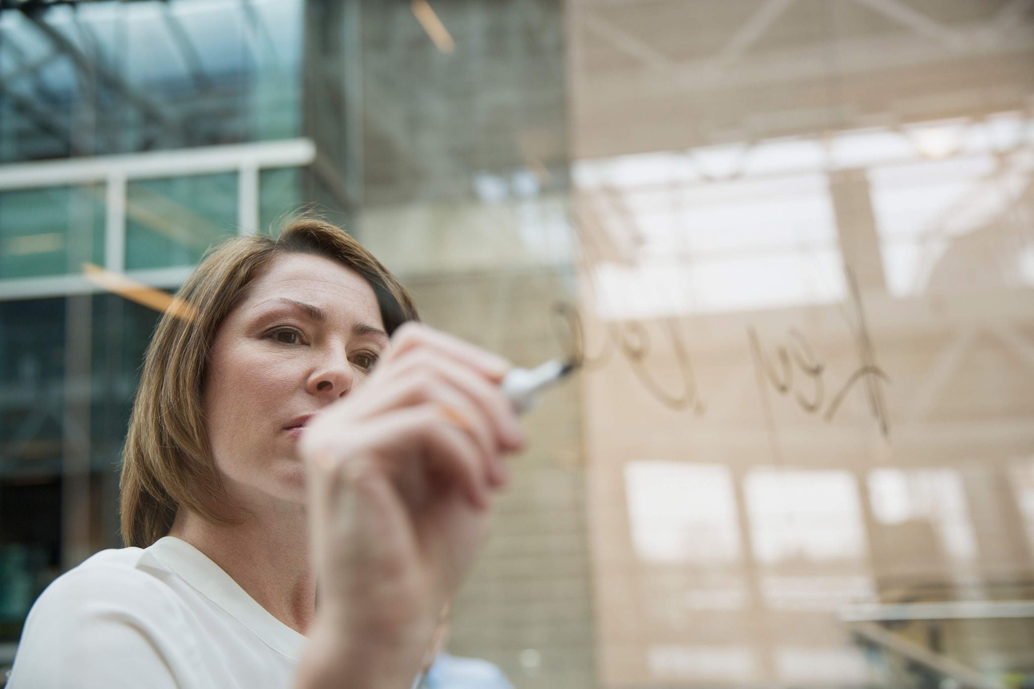 Business woman writing on glass