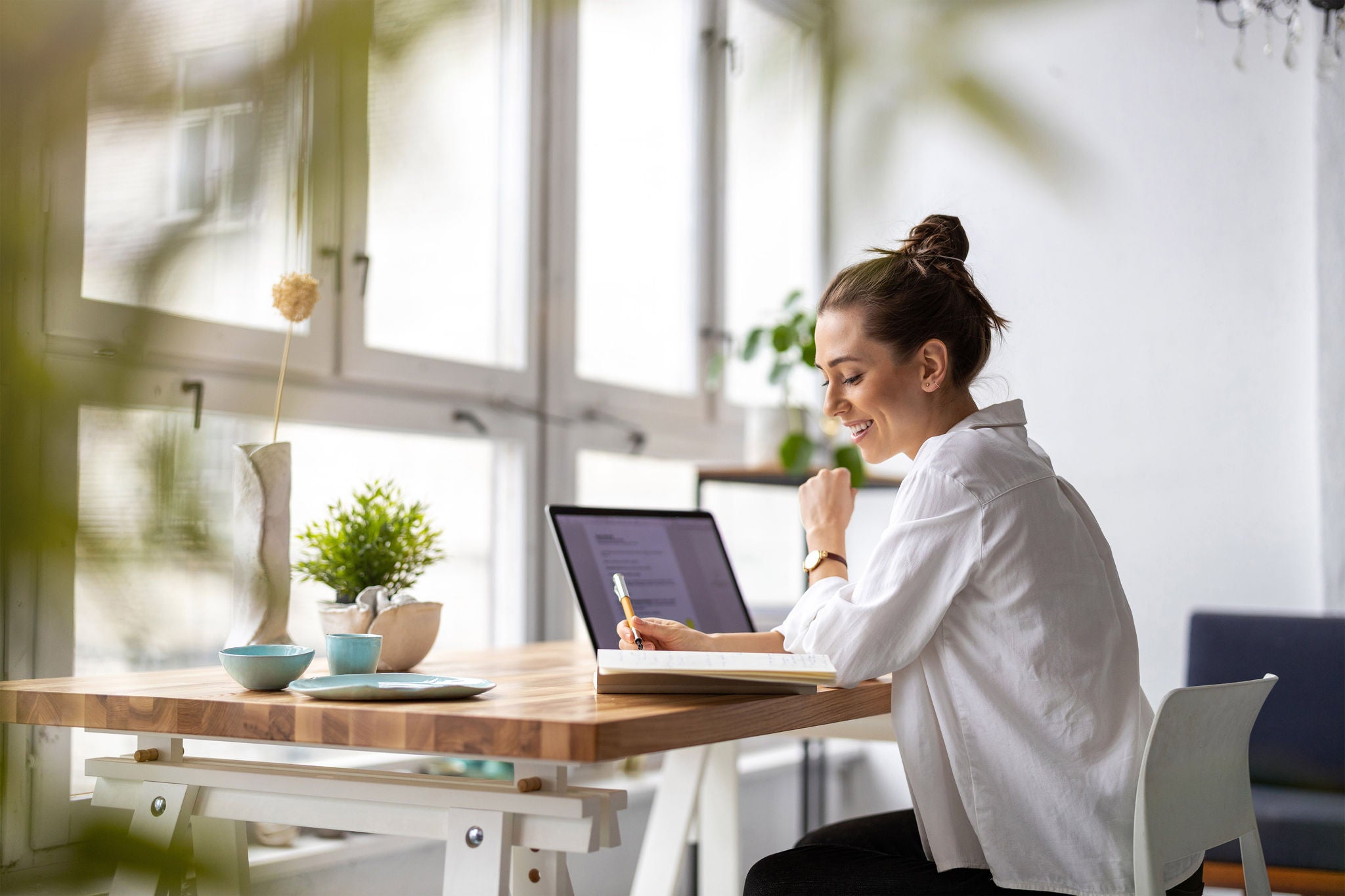 Women working on laptop and writing a notes