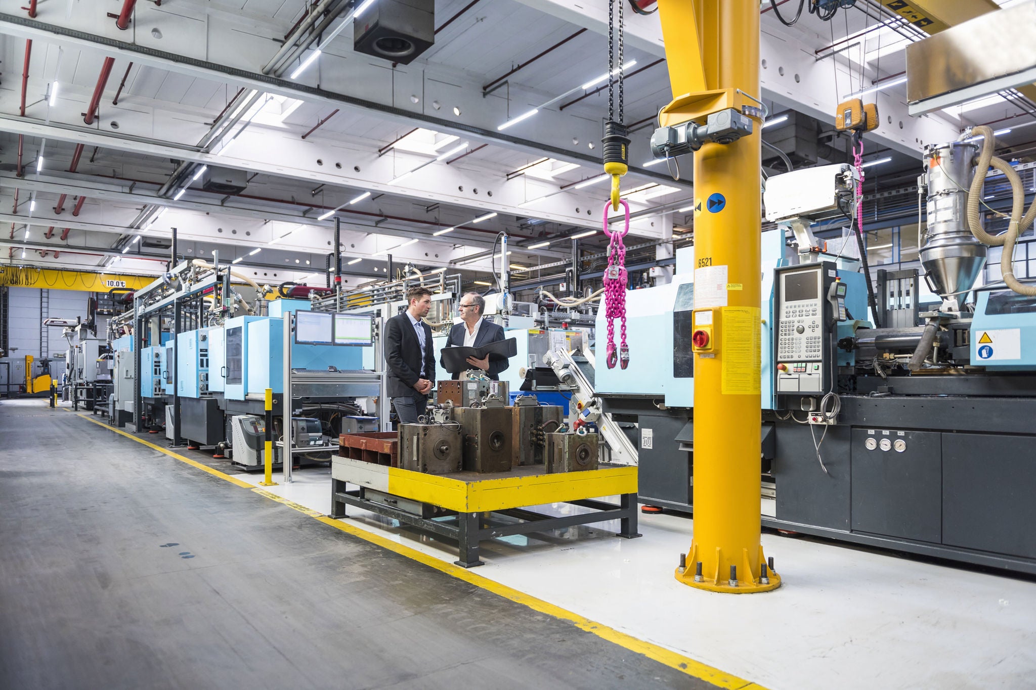 Two men documents talking factory shop floor