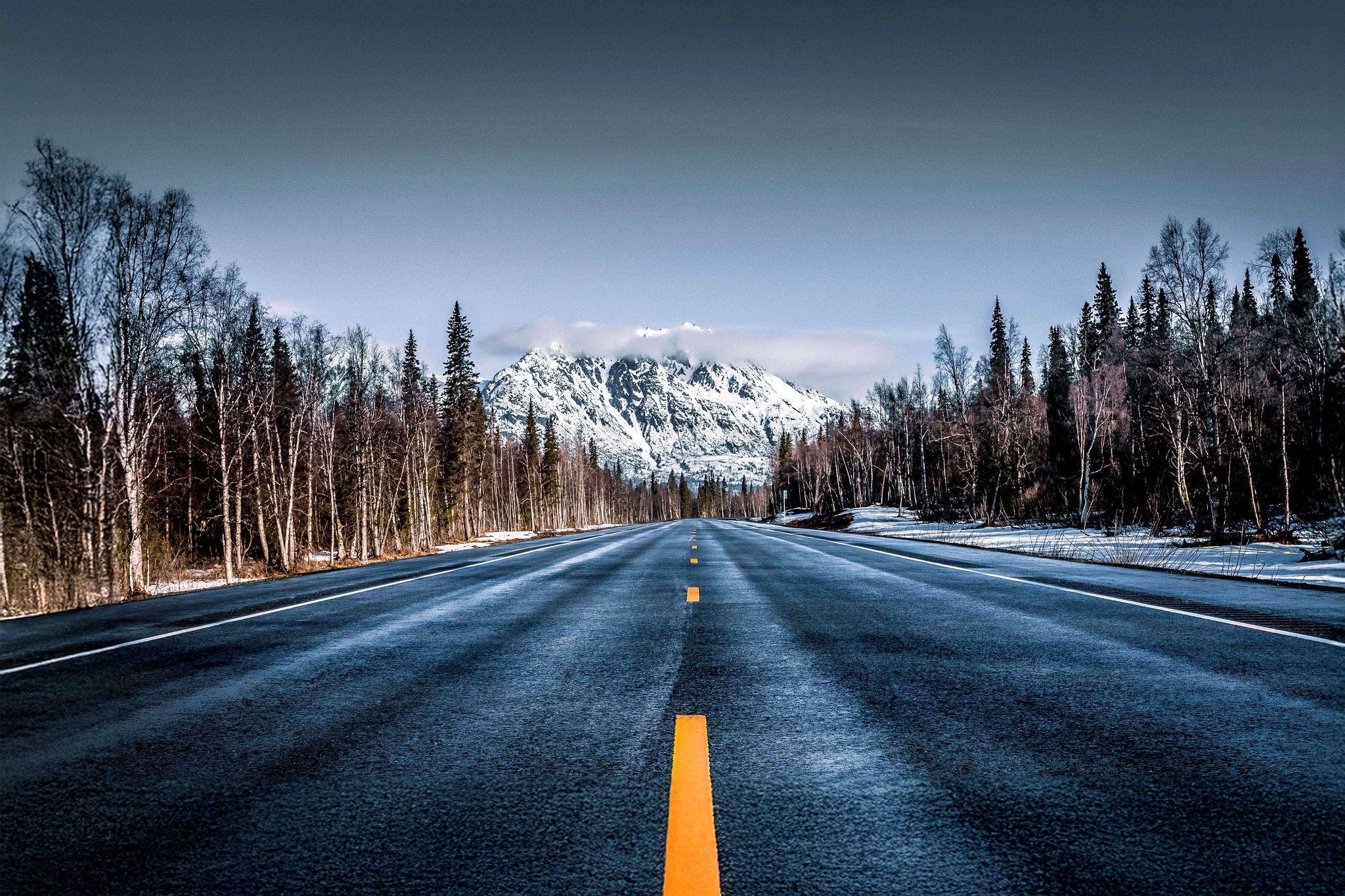 Empty country road against sky during winter