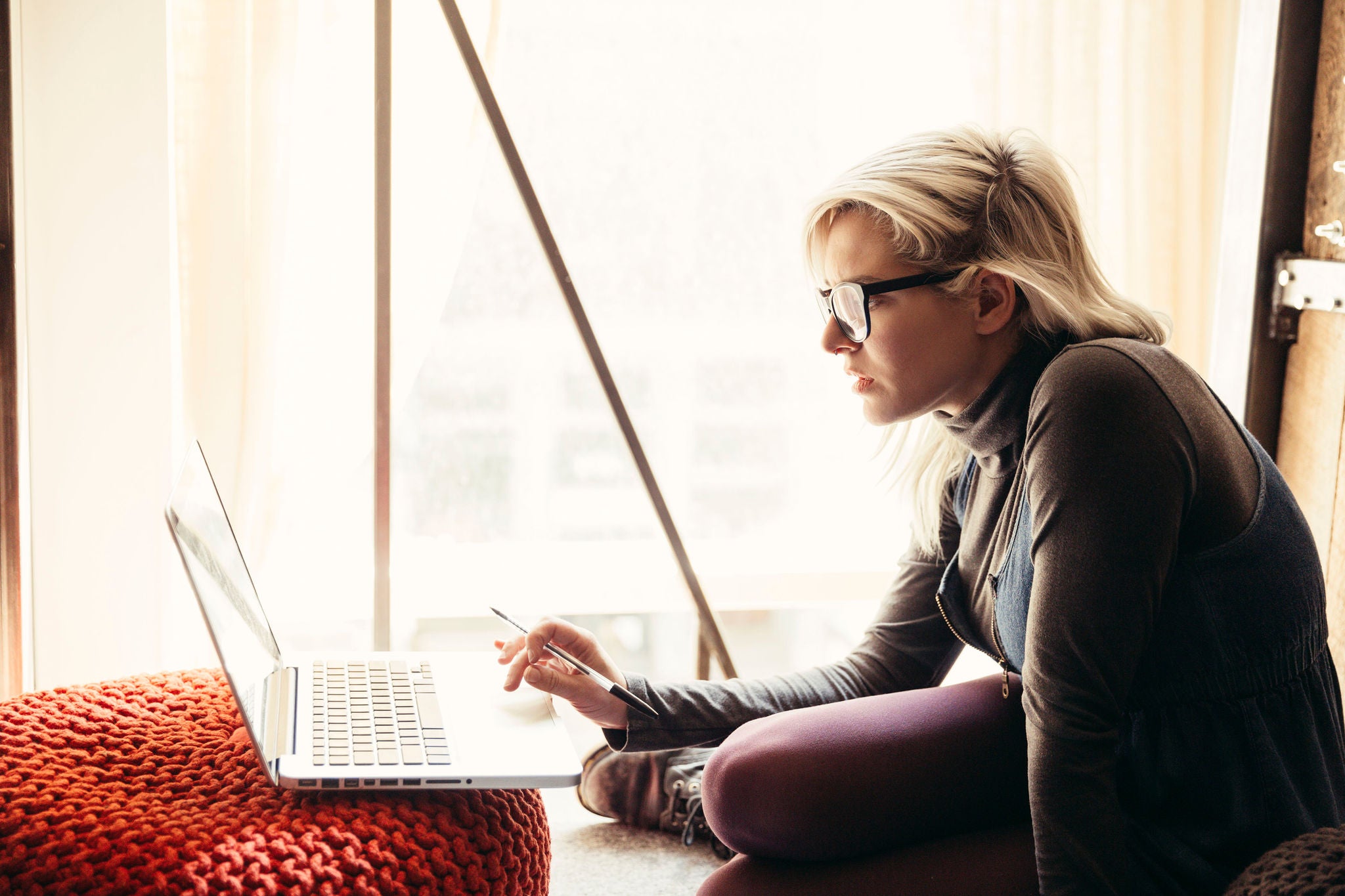 A businesswoman is using a laptop in a creative office.