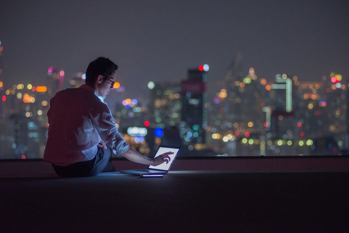  A man working in the laptop by sitting on terrace