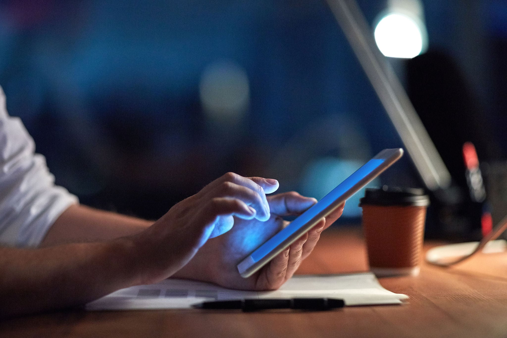 Cropped shot of a businessman using a digital tablet at night in an office