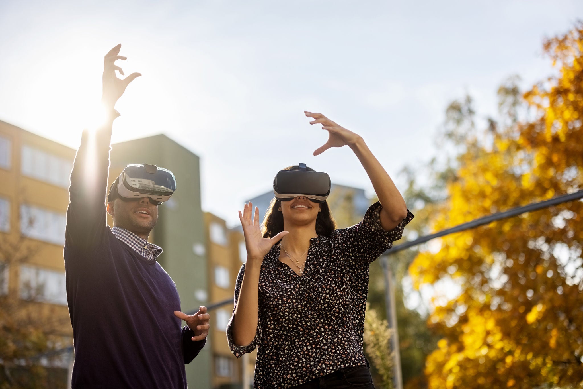 couple using VR simulator outdoors city 