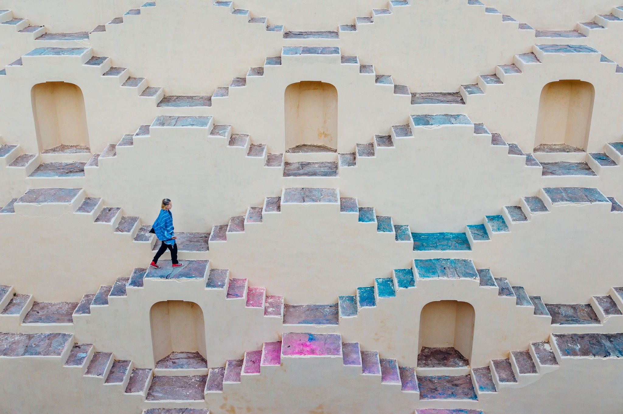 EY person walking up across colourful stairs