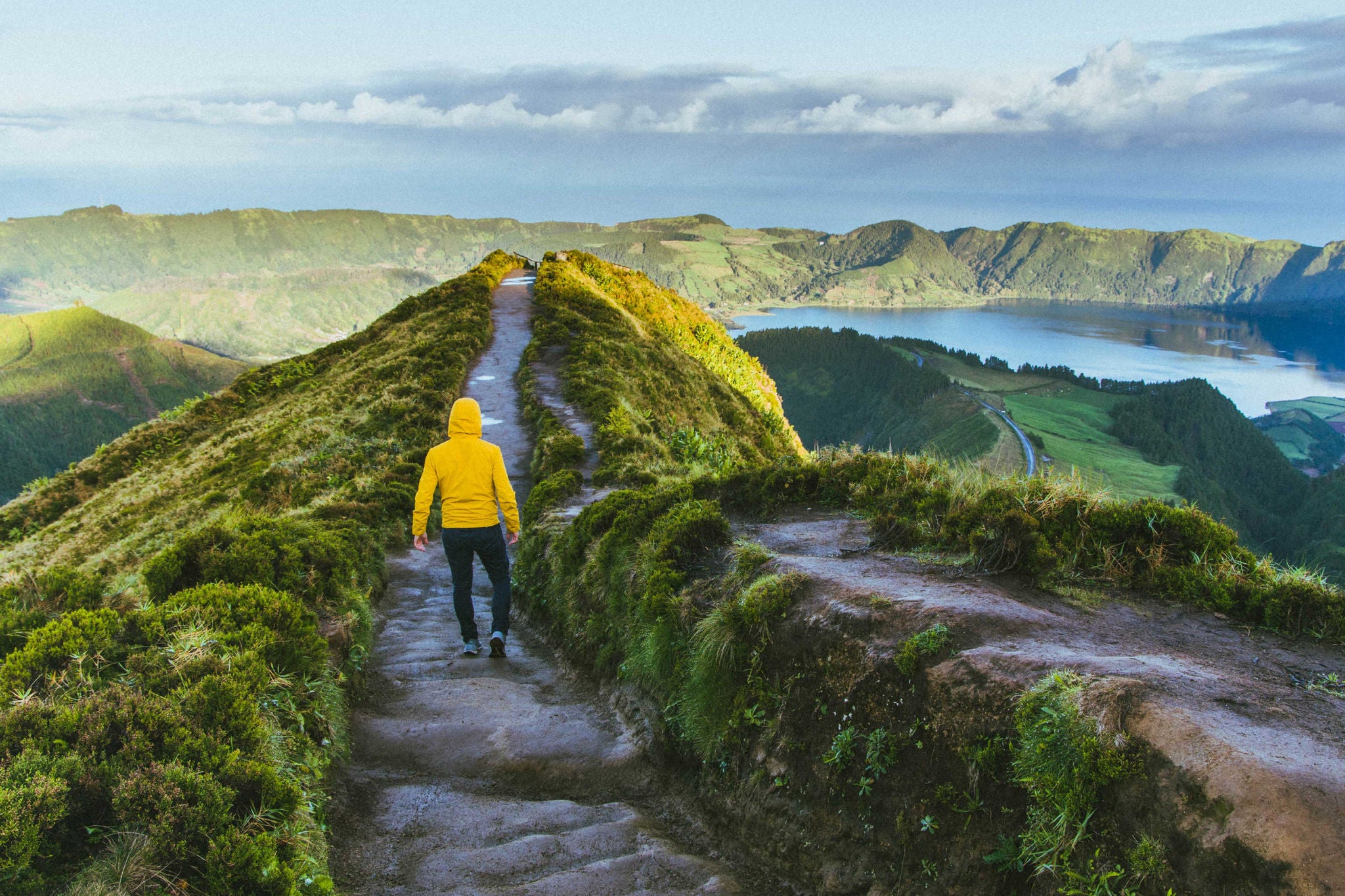 Hombre con campera amarilla caminando por la naturaleza