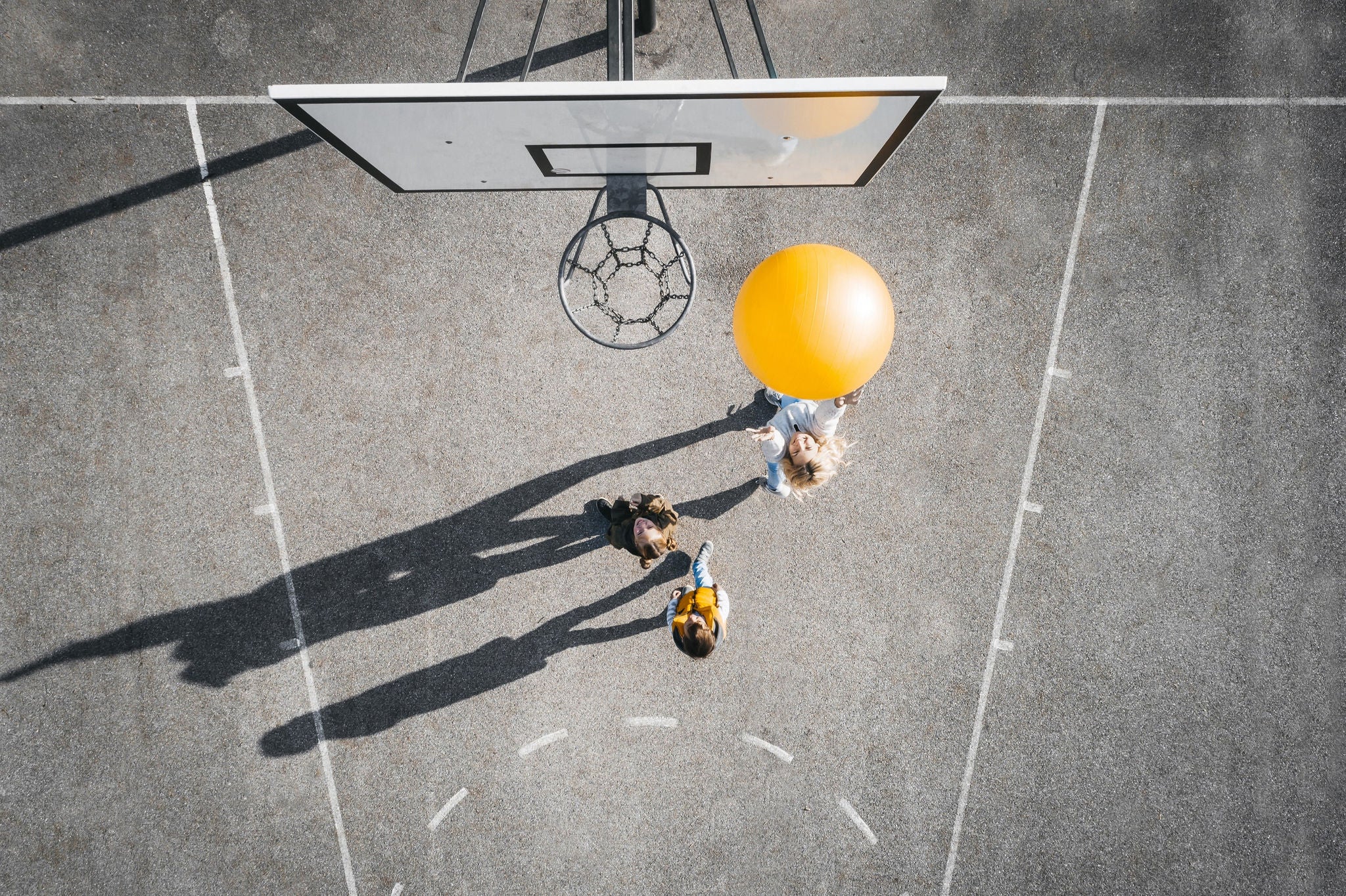 Women playing basketball with children's