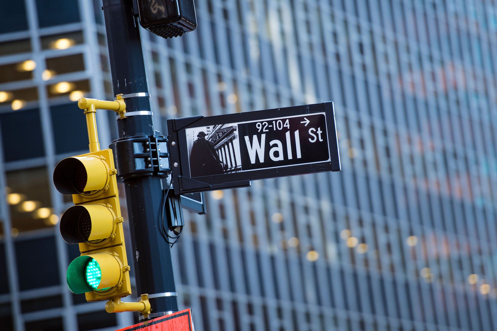 Wall street sign in the foreground and a blurred building in the background