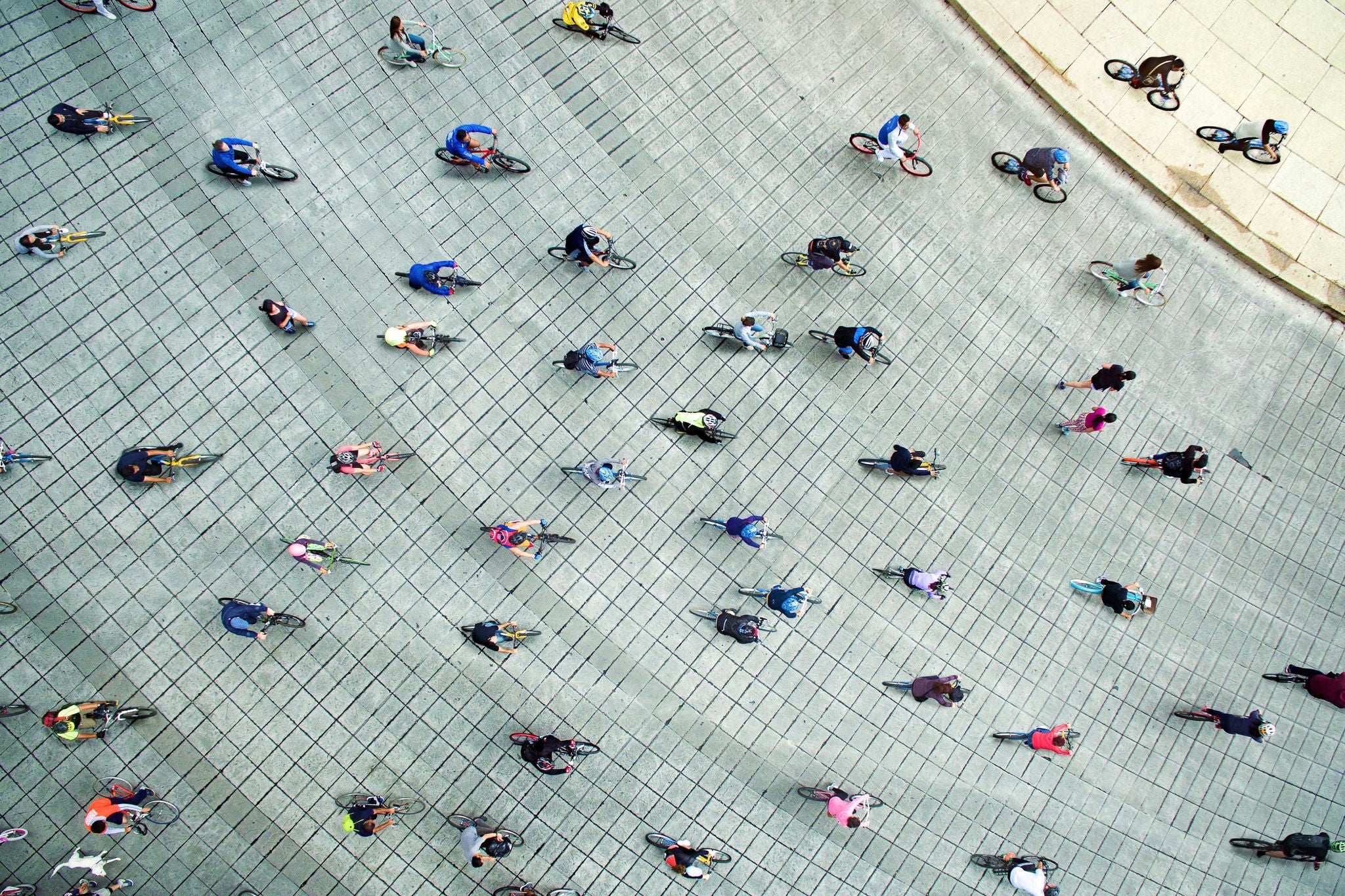 Aerial view people cycling on street grid