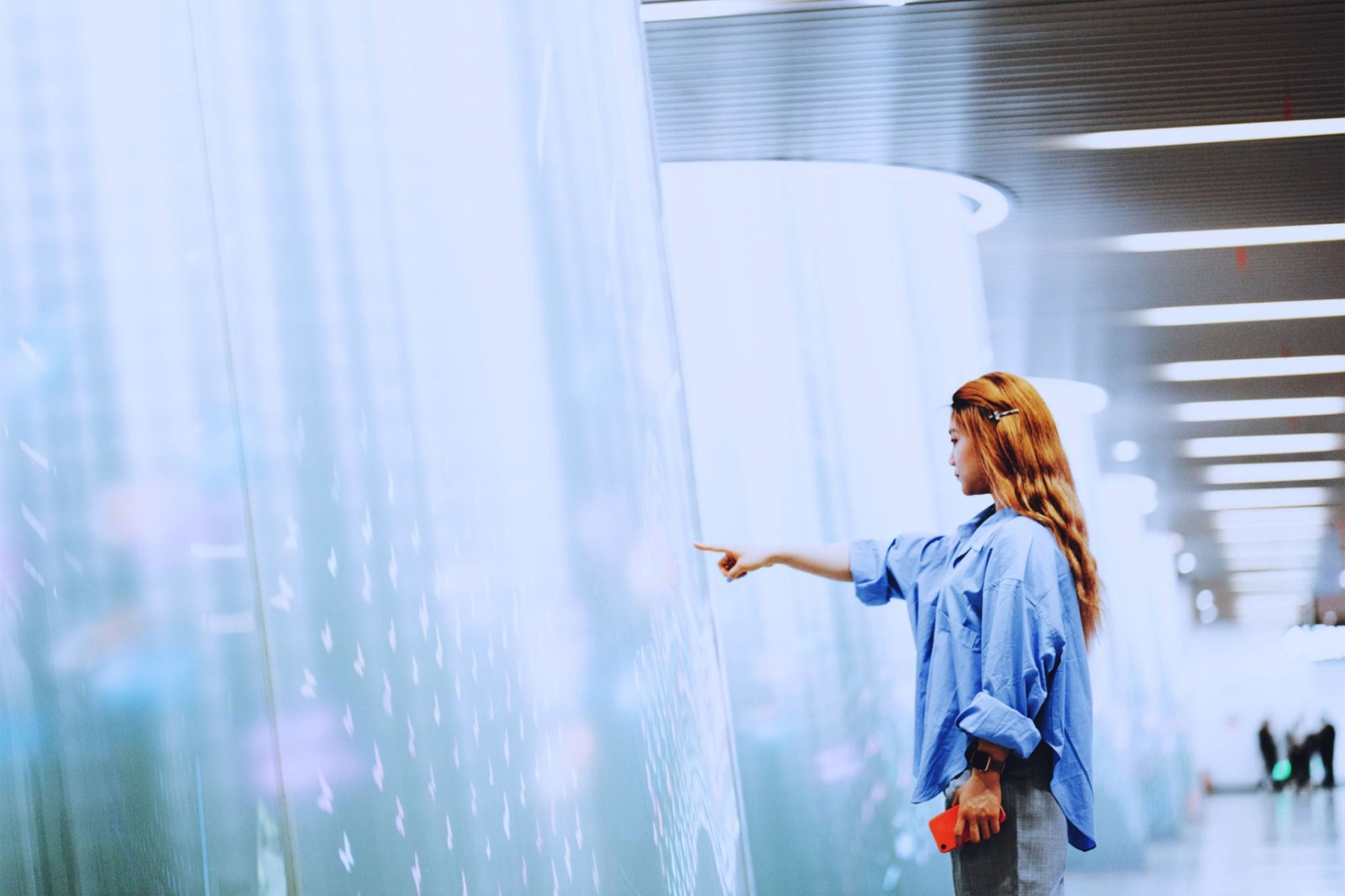 Businesswoman touching a beam of light by hand at the subway station