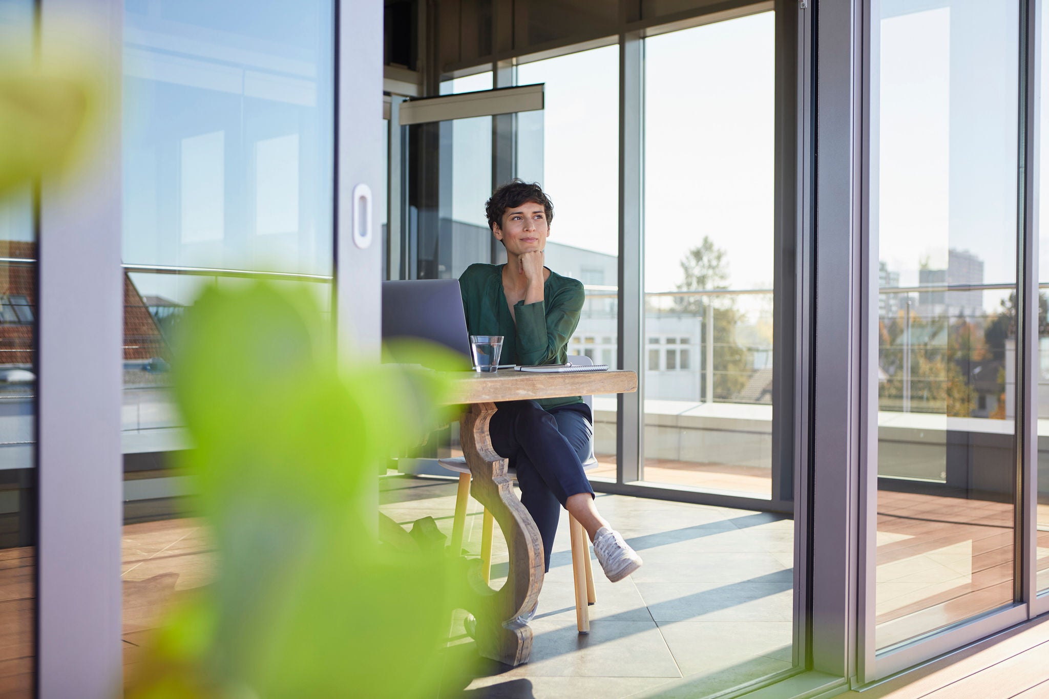 Smiling businesswoman sitting at table with laptop