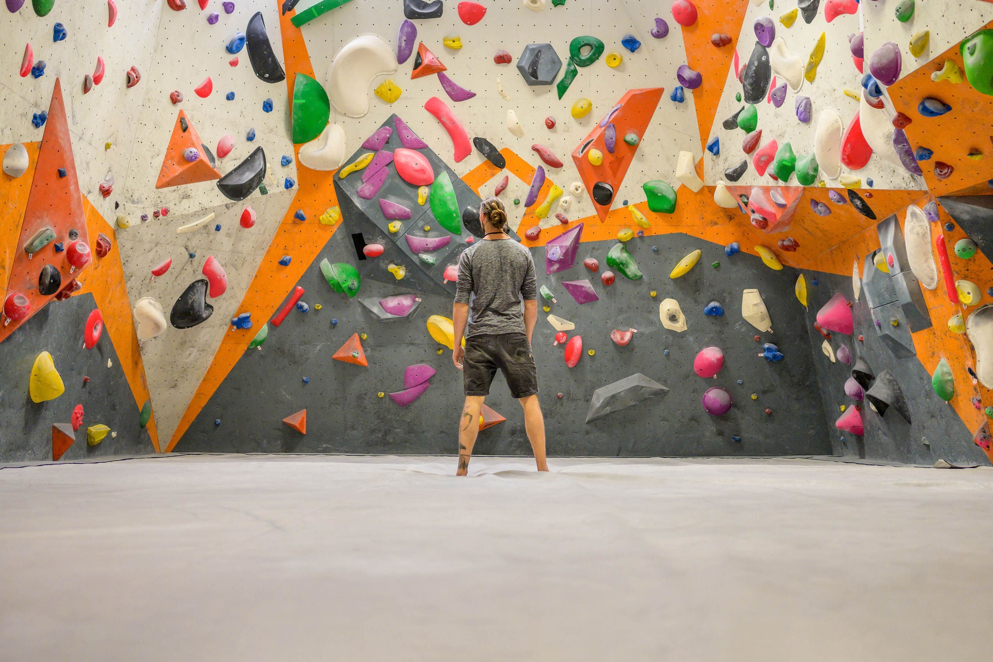 Mann in Kletterhalle stehend