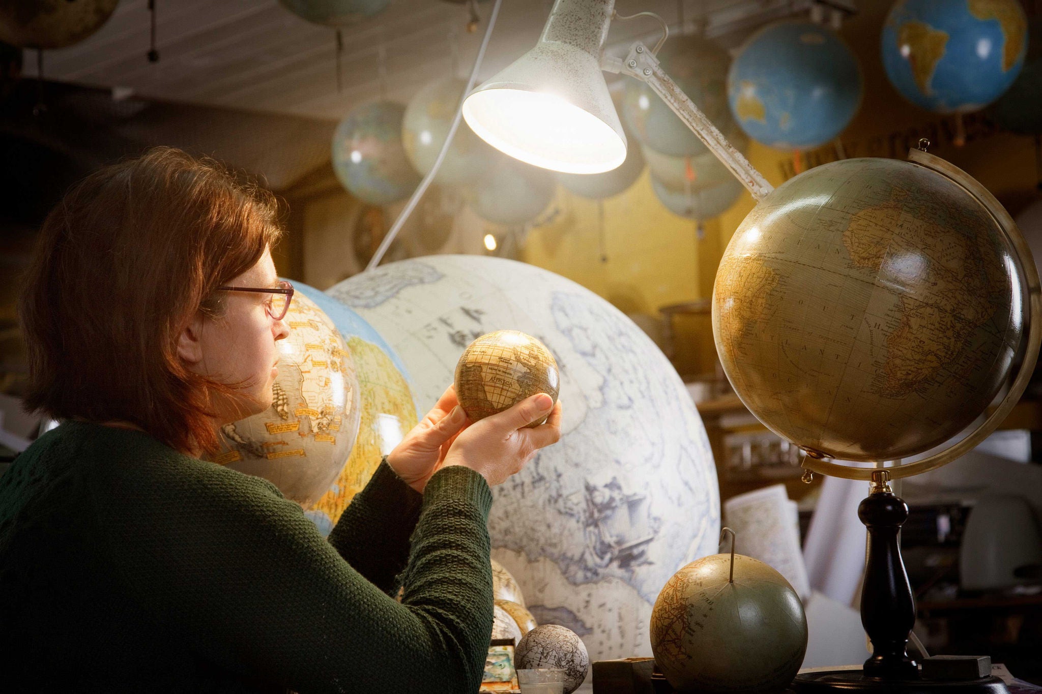 Globe Maker Examining Work in Progress