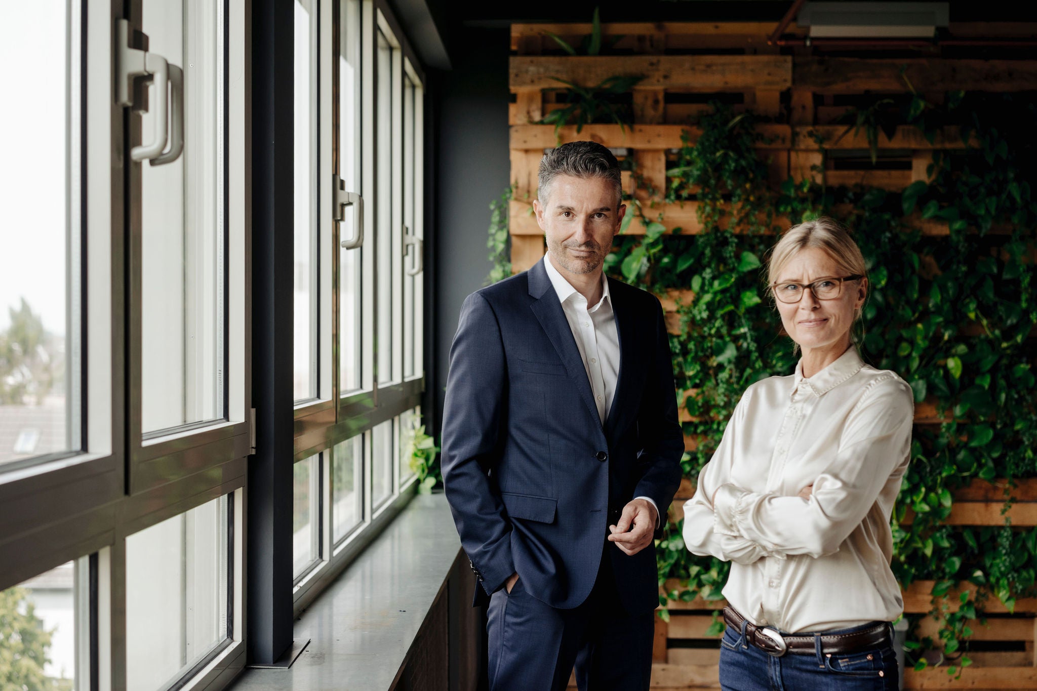  Confident businessman and businesswoman in green office