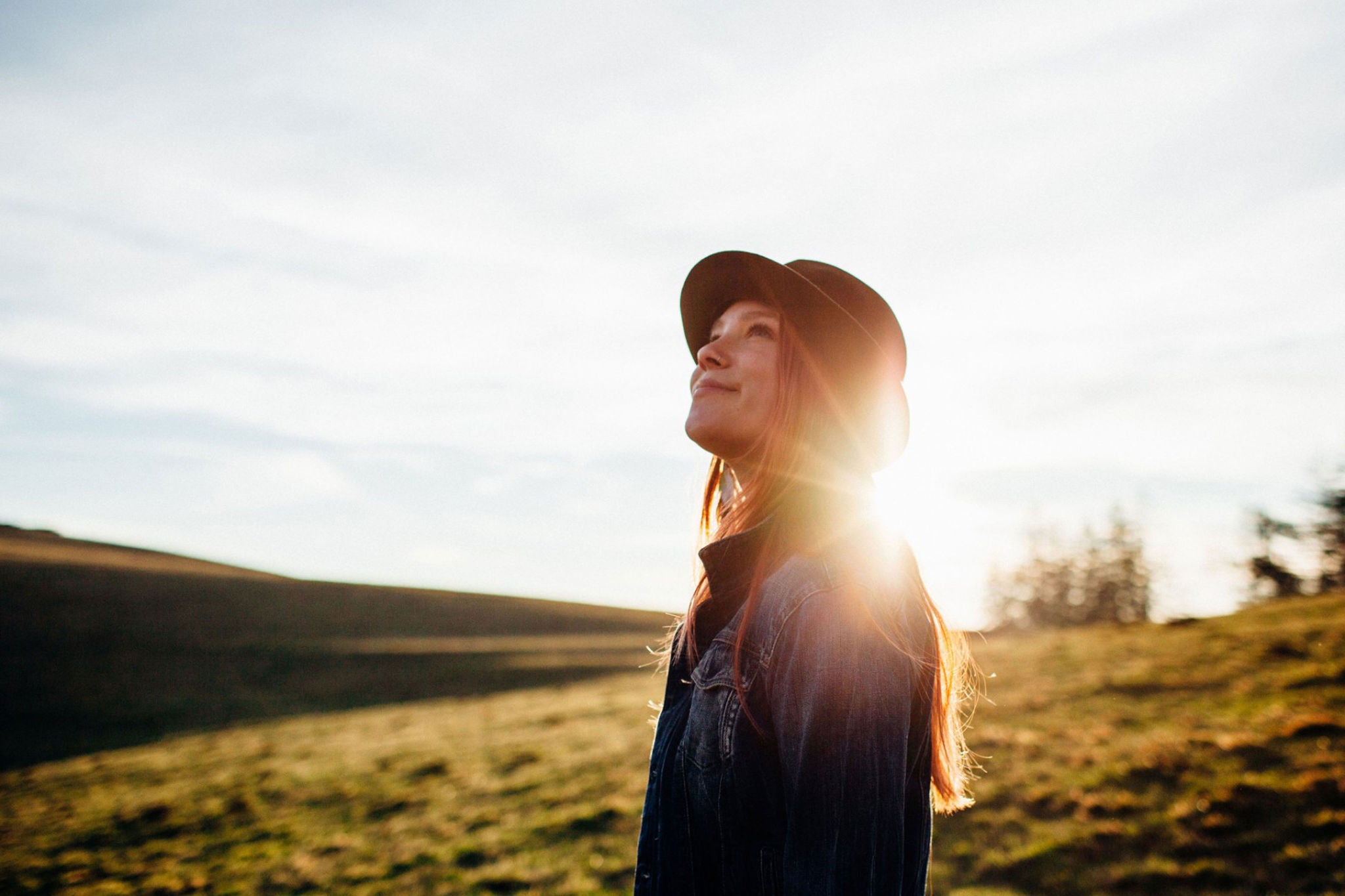 ey girl with hat looking upwards in the black forest germany