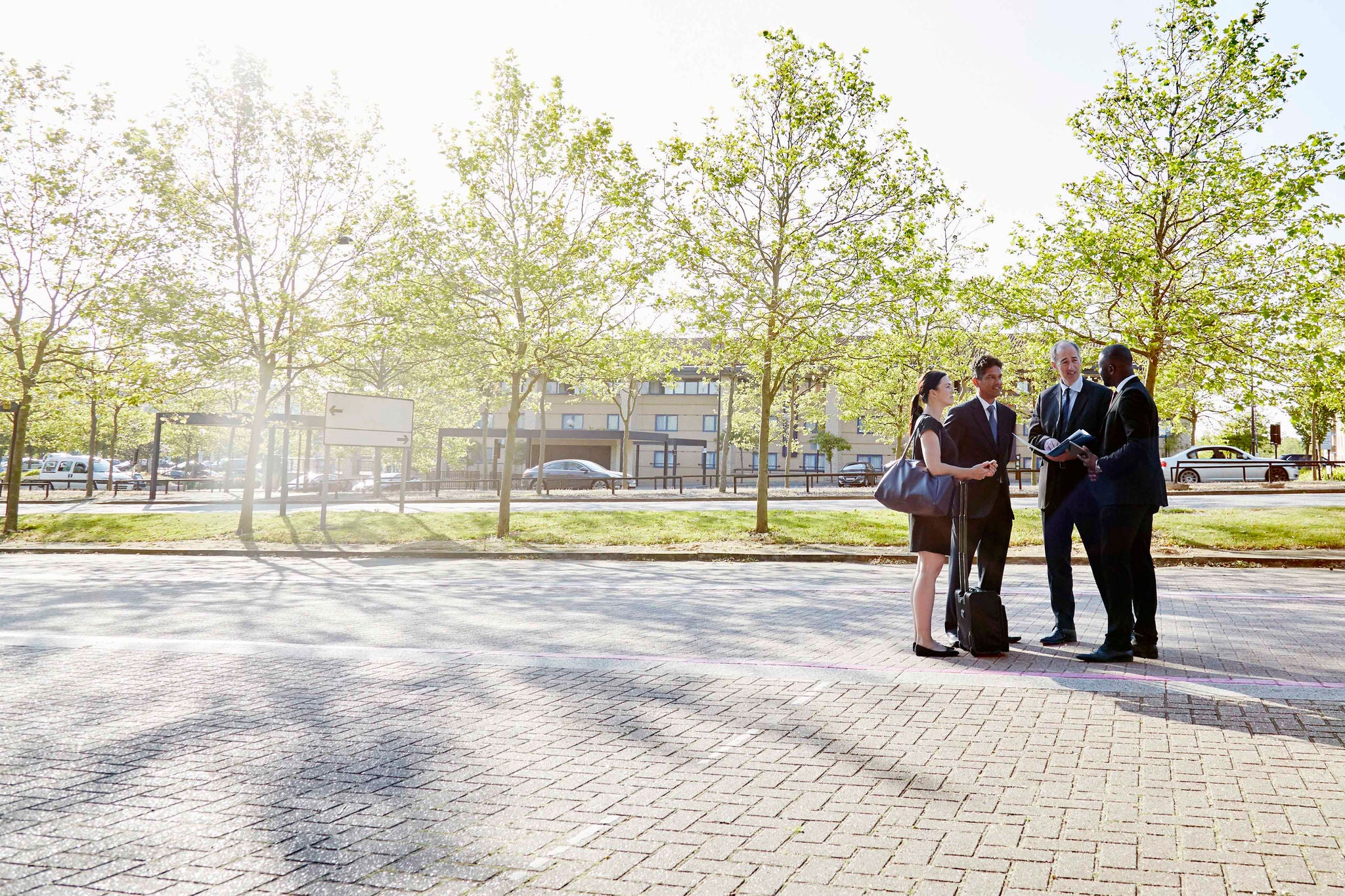 Image of collegues dressed in formals having a conversation outside