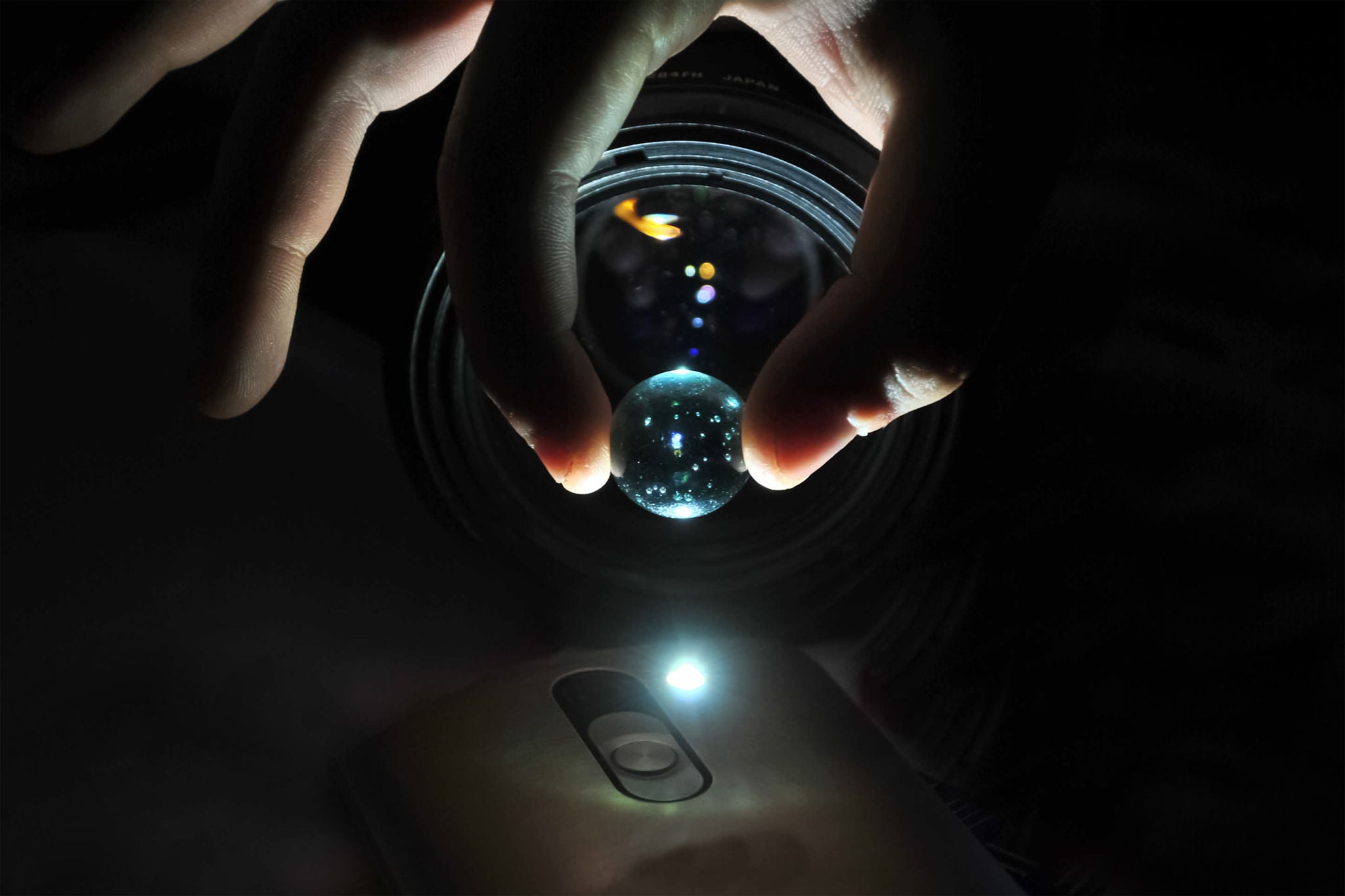 CLOSE-UP OF HAND HOLDING ILLUMINATED LIGHT BULBS